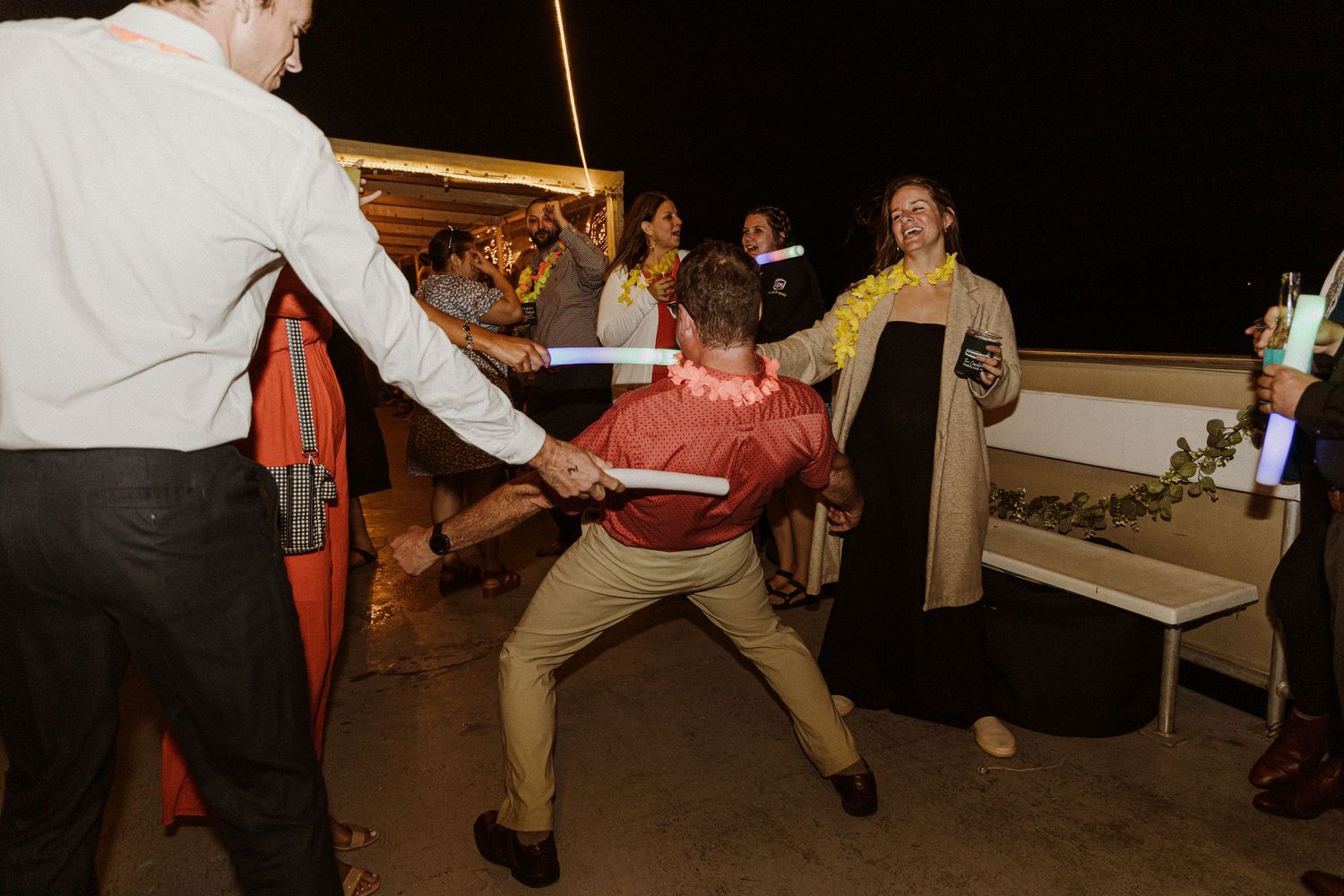 Party guests engaged in energetic dancing and celebration at a nighttime event.
