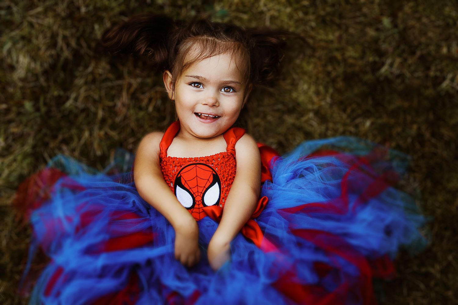 Child wearing a Spider-Man tank top with a bright blue and red tutu dress.