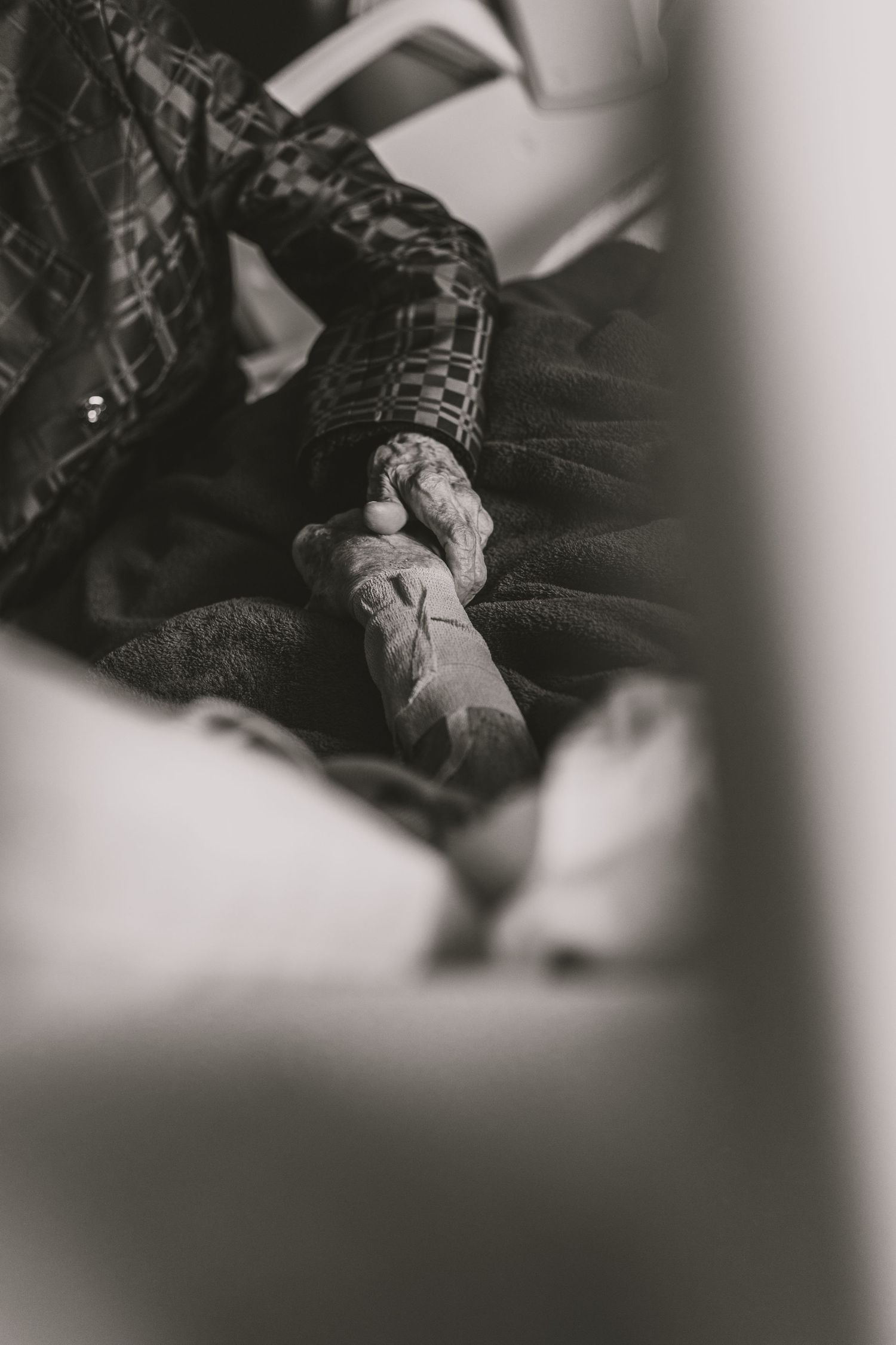 A black and white close-up shot of a tattooed arm in a leather jacket sleeve, creating a moody artistic aesthetic.