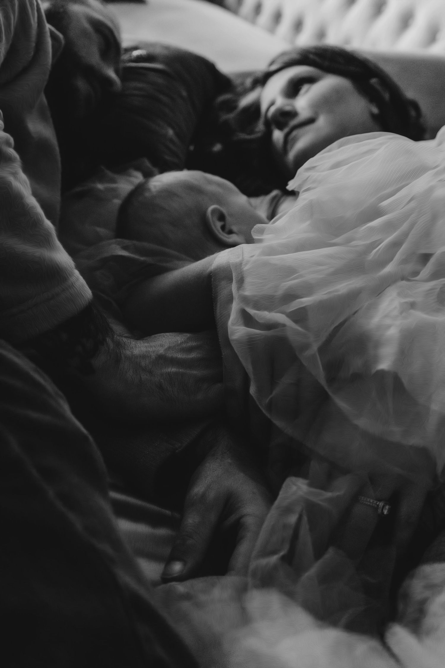 Black and white image of mother and newborn resting together.
