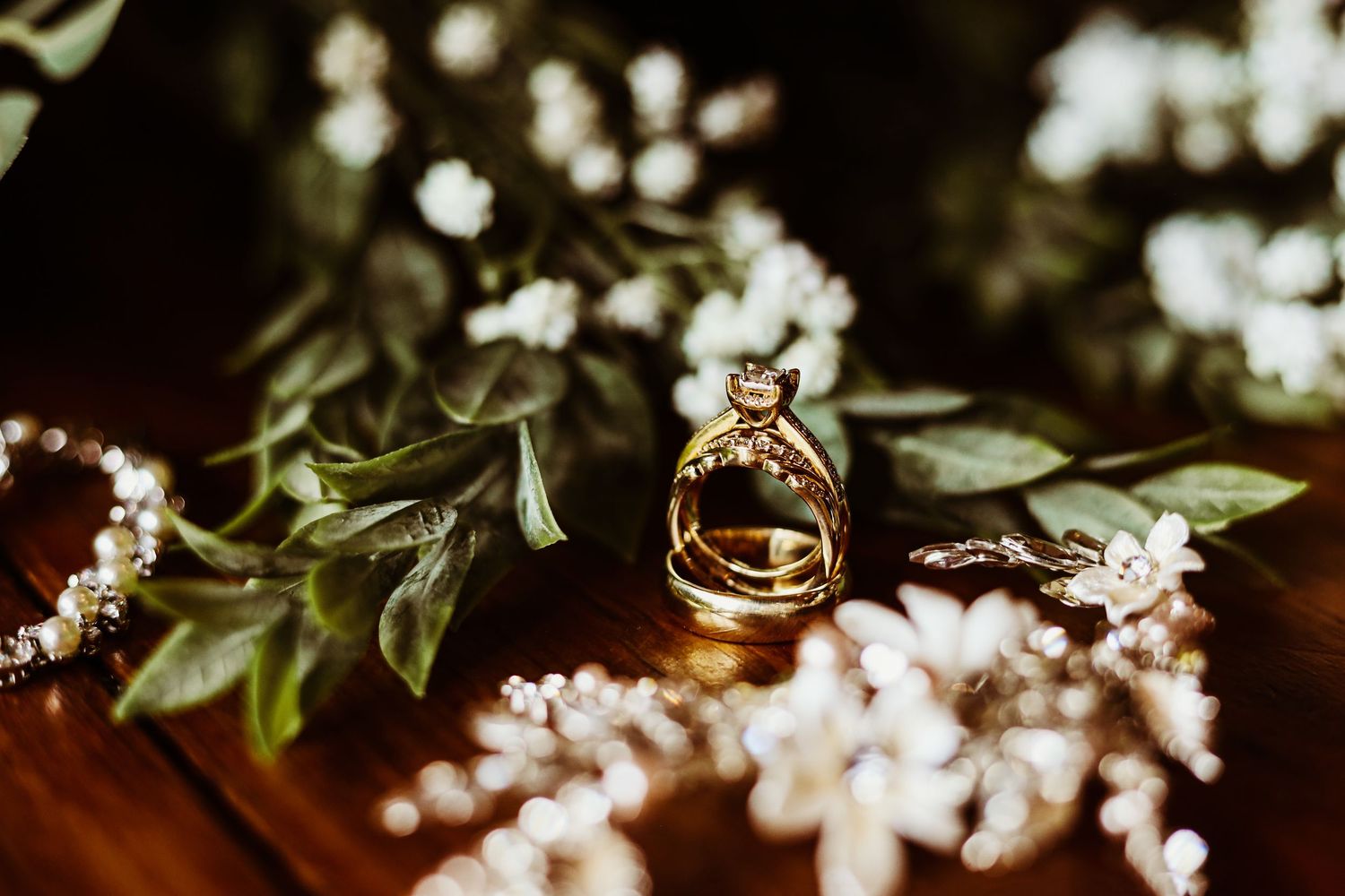 Wedding rings photographed with delicate white flowers and greenery.