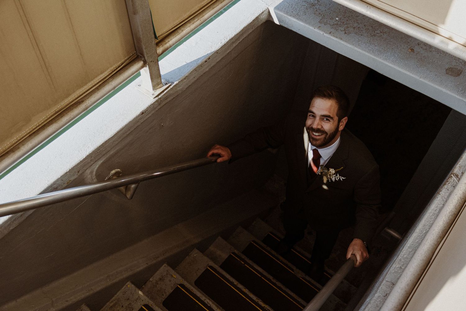 View looking up stairwell at person ascending in formal attire.