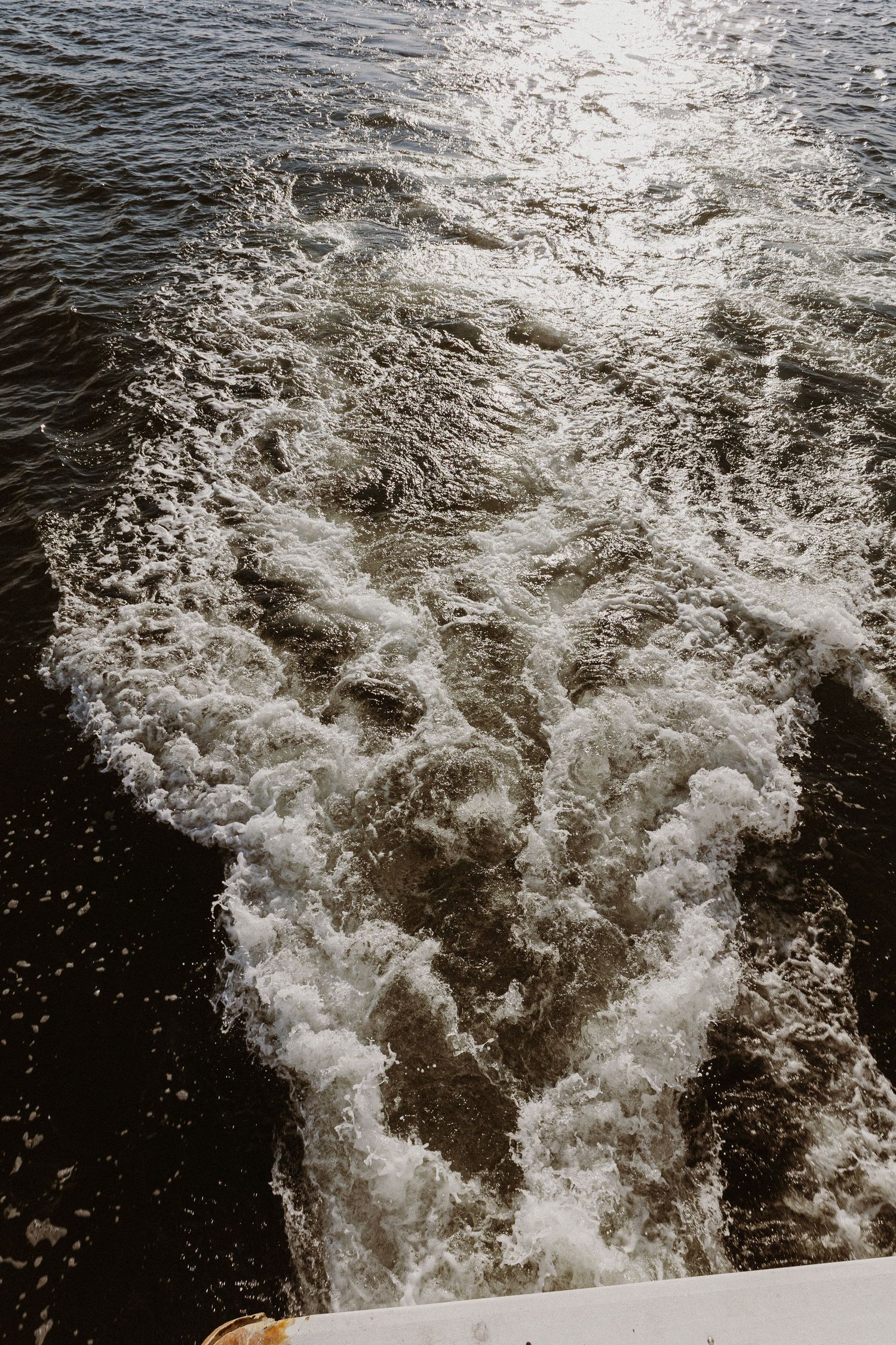 Wake pattern in dark water creating dramatic white foam trails.