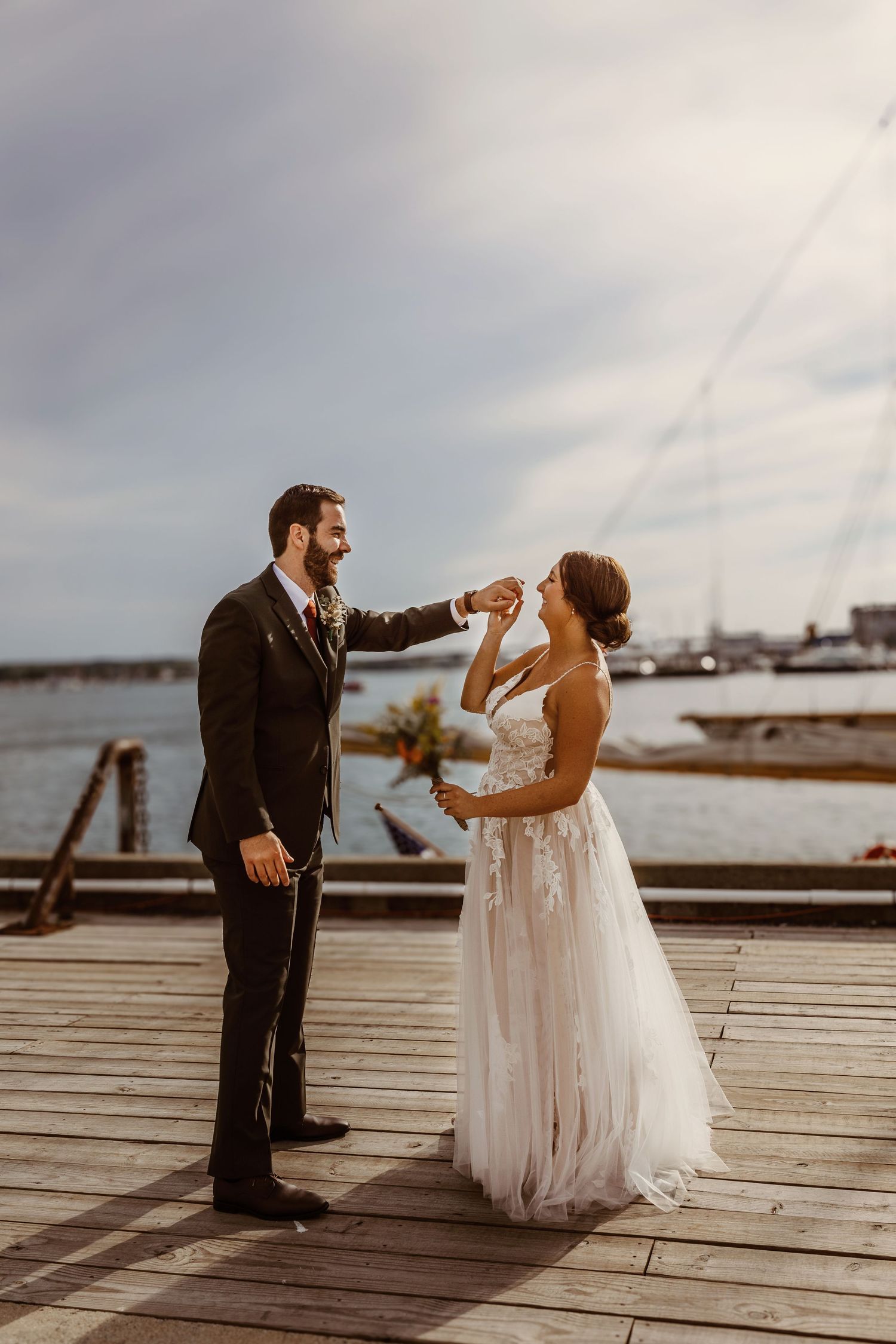Couple sharing intimate moment on wooden dock by waterfront.