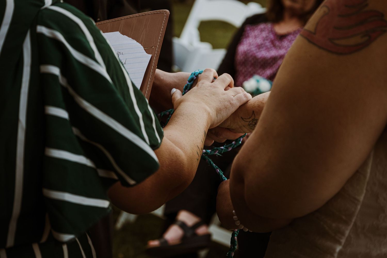 Close-up of hands holding or writing in a small notebook during an event.