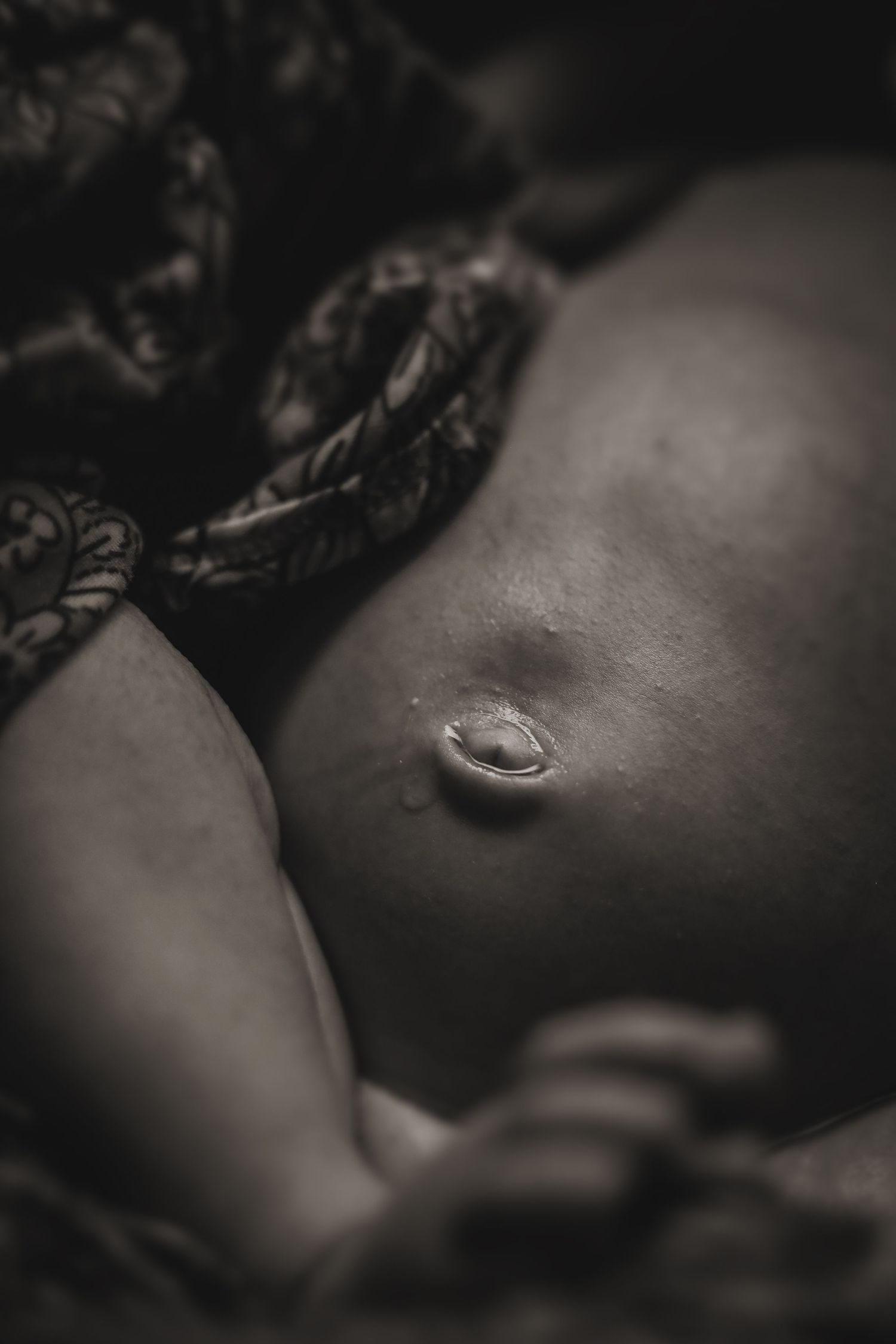 Black and white macro photograph of a belly button in soft focus.