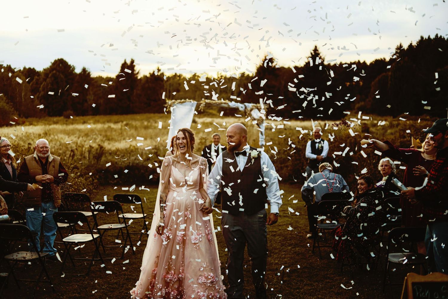 Wedding celebration with confetti falling during an outdoor ceremony.