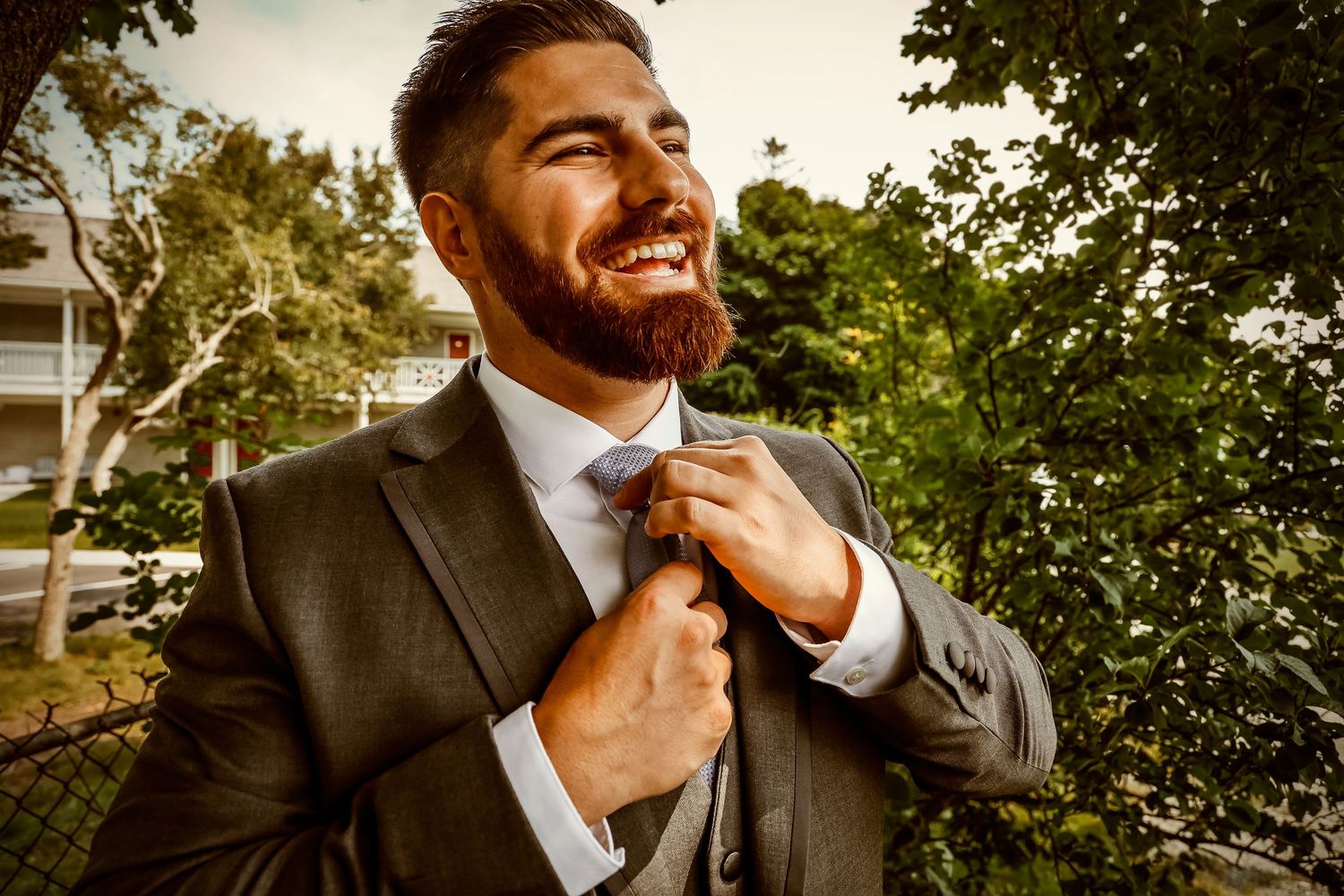 Joyful moment as formal attire is adjusted in natural outdoor lighting.