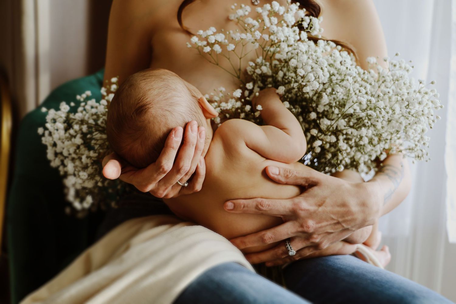 Gentle maternity photo with white baby's breath flowers creating soft, dreamy atmosphere.