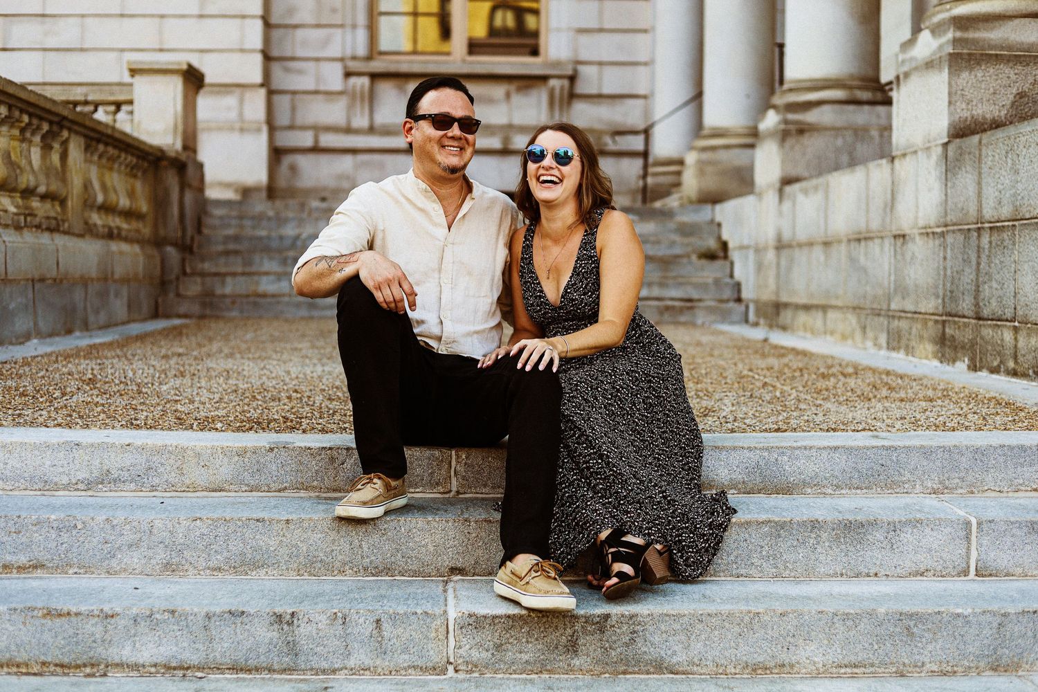 Couple sitting on stone steps of a historic building.