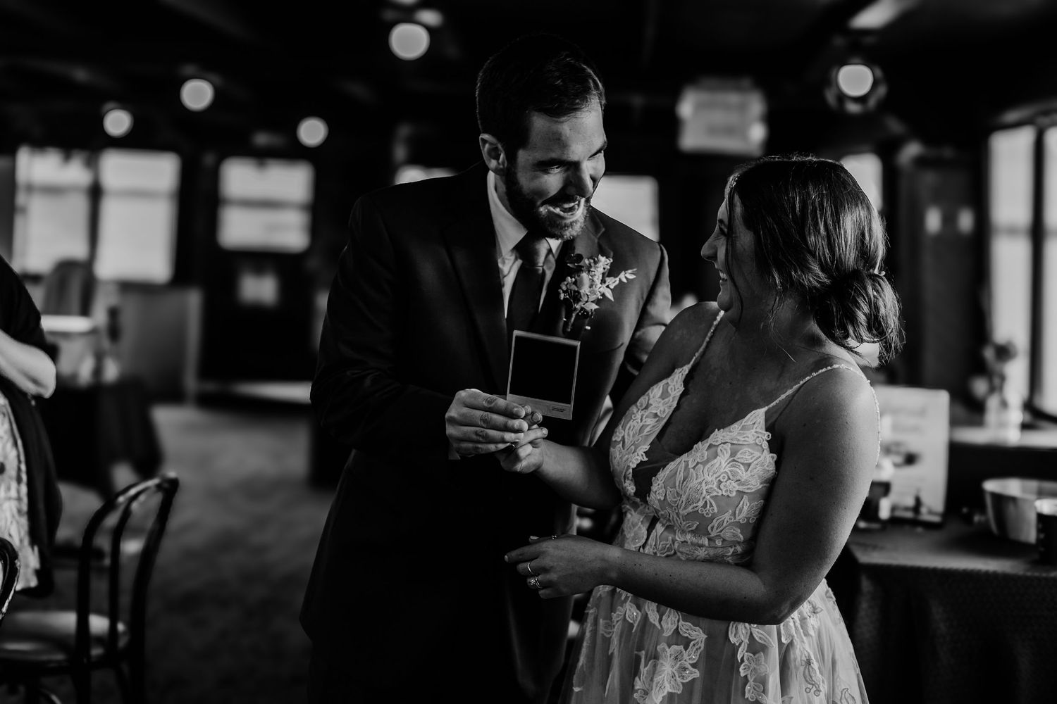 A tender moment shared between a couple examining a document in a dim indoor setting.
