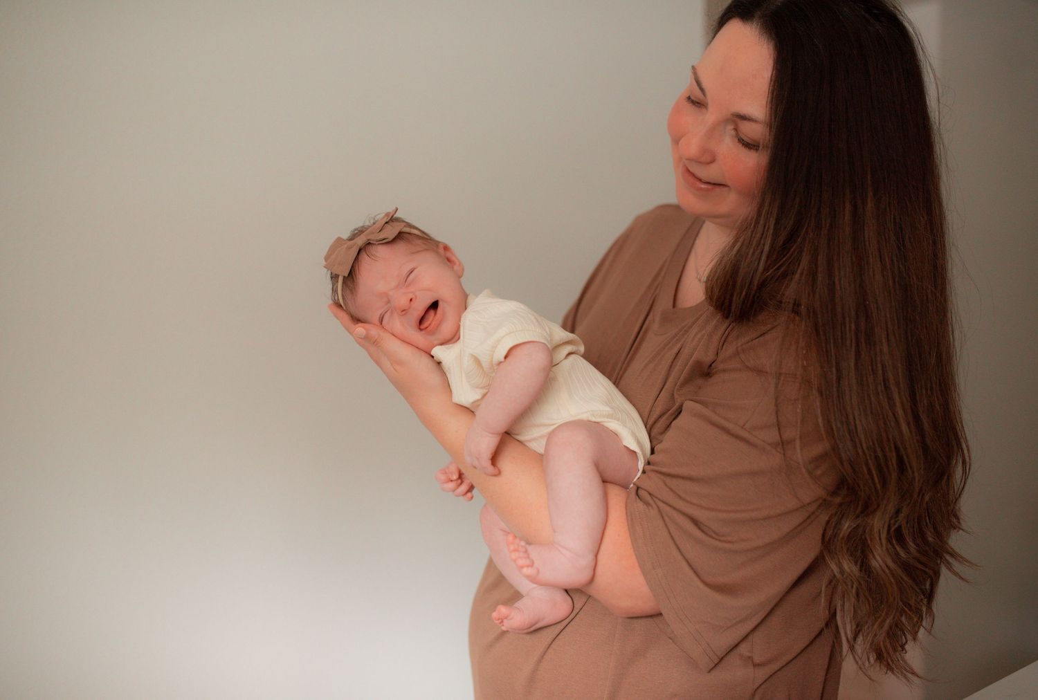 mother holding newborn, newborn crying