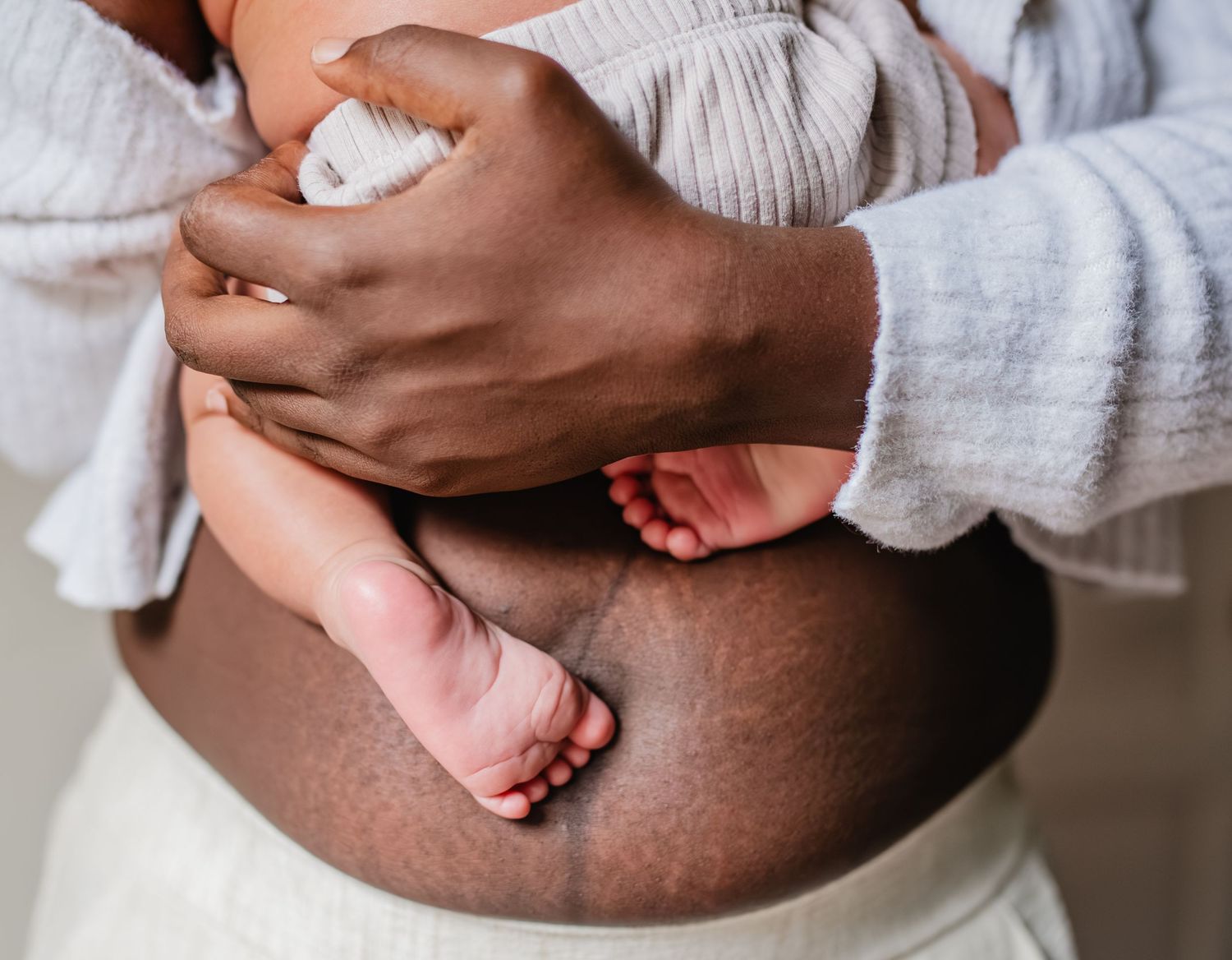 newborn babies feet resting on moms belly