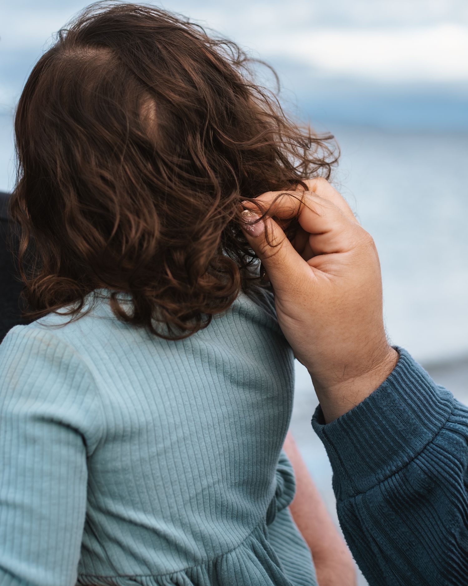 Mom touches and plays with daughters hair