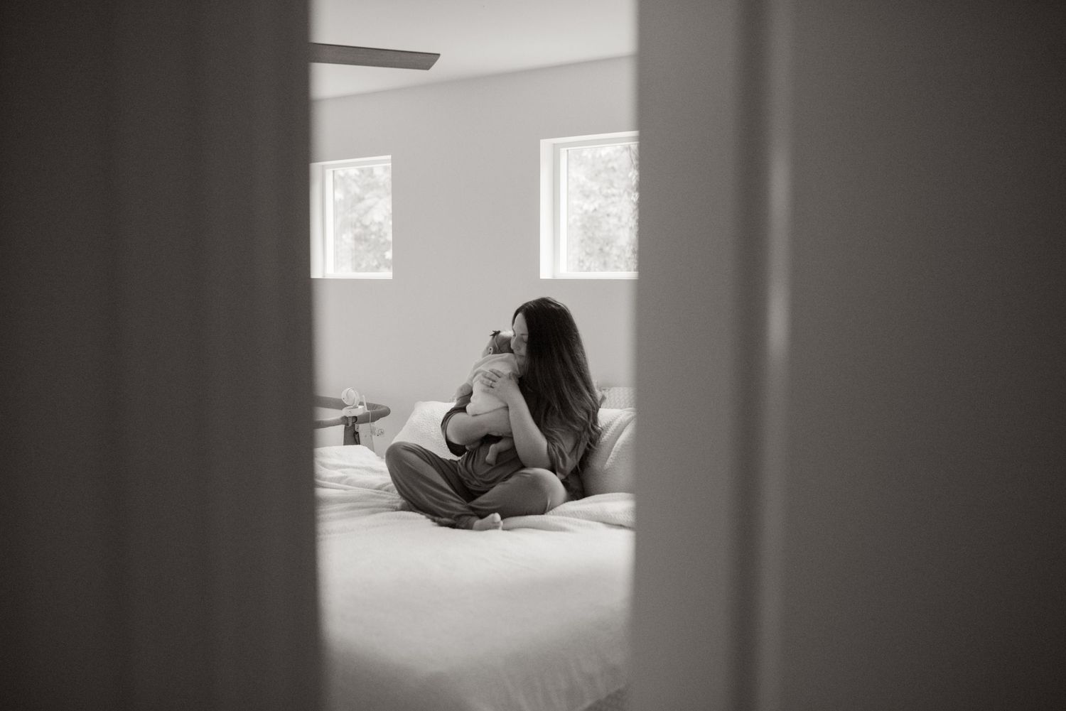 mother sitting on bed with newborn
