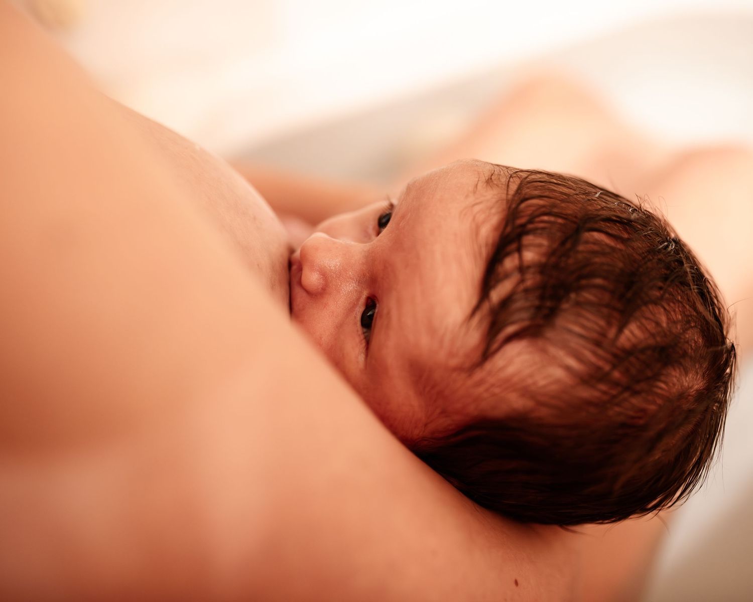 baby girl nursing in the bath during a newborn session