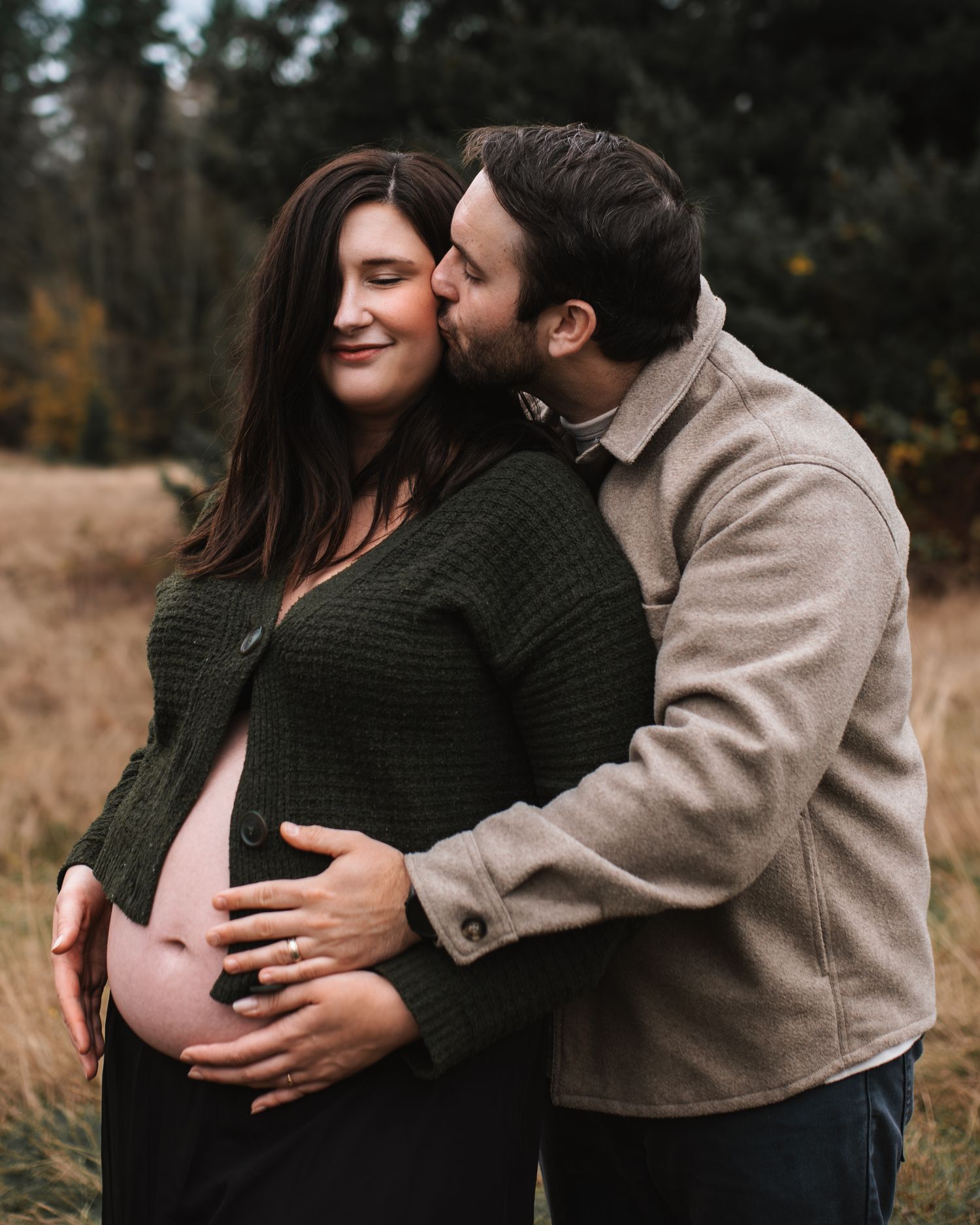 Dad holding mom and touching her belly during a maternity session