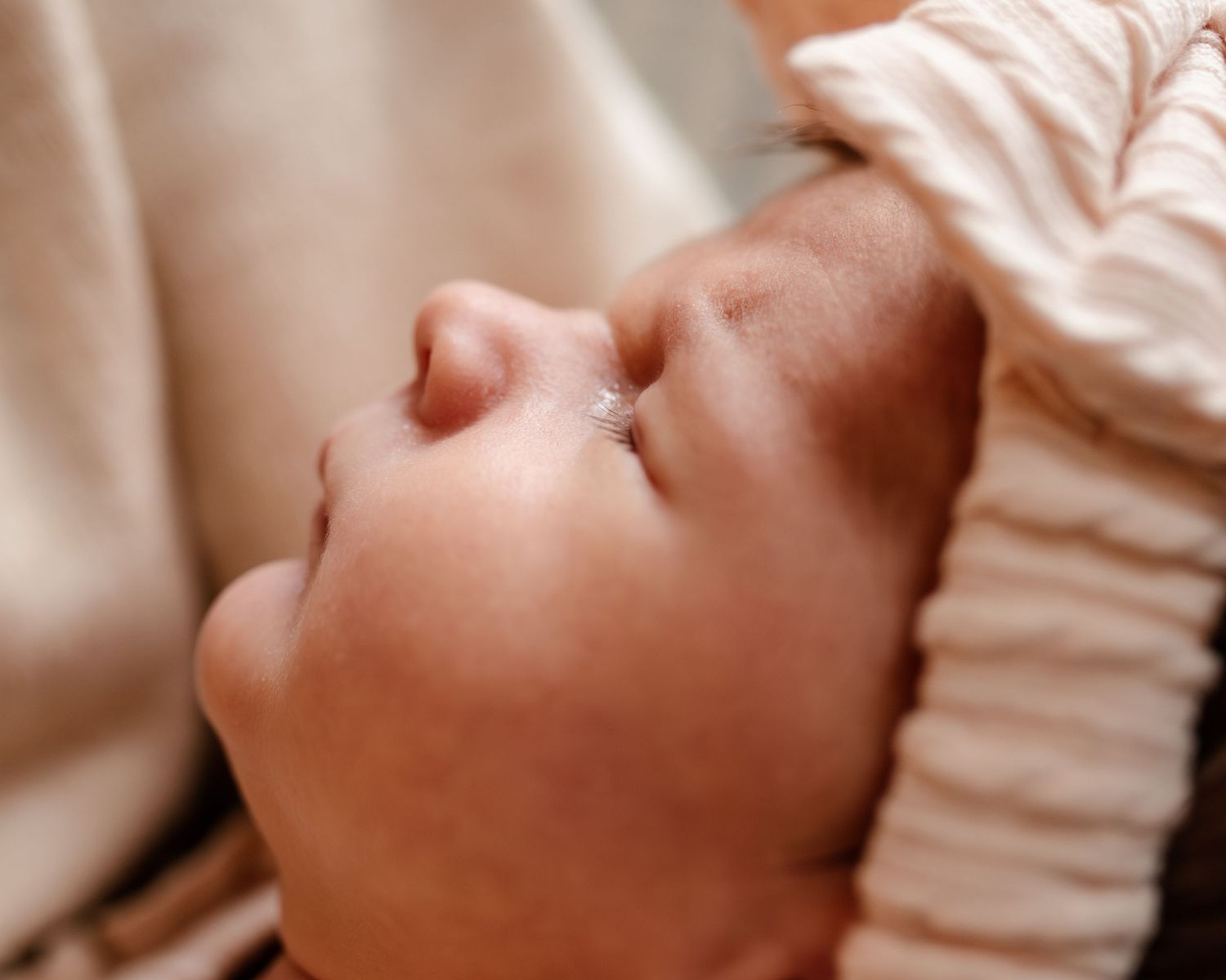 close up of a newborns face, highlighting her nose and facial features