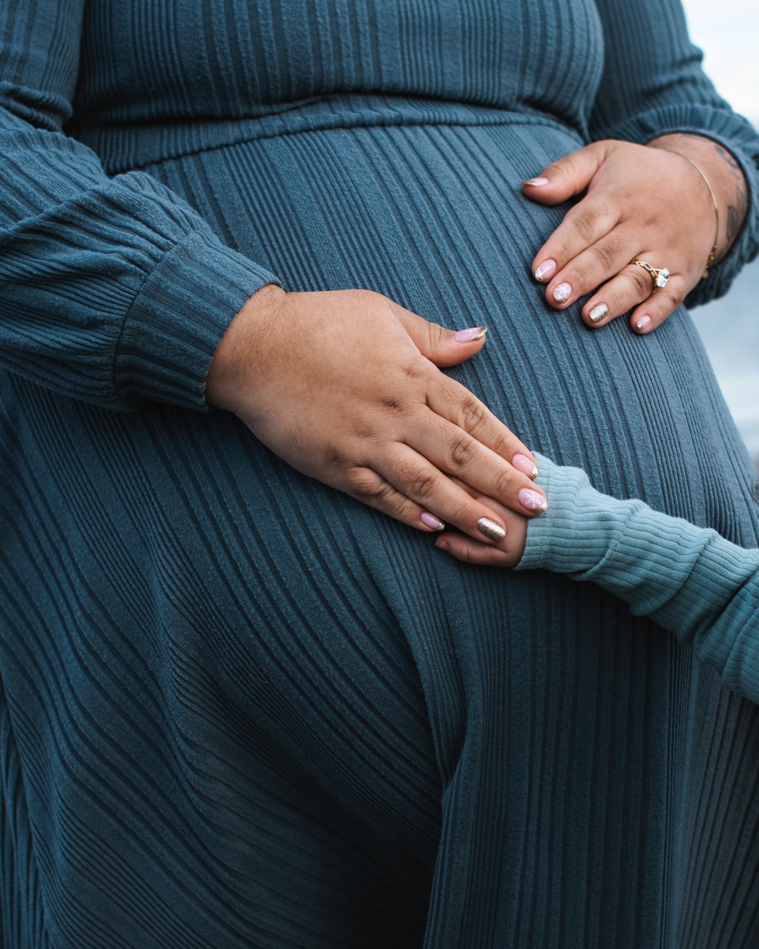 child has their hand on moms pregnant belly