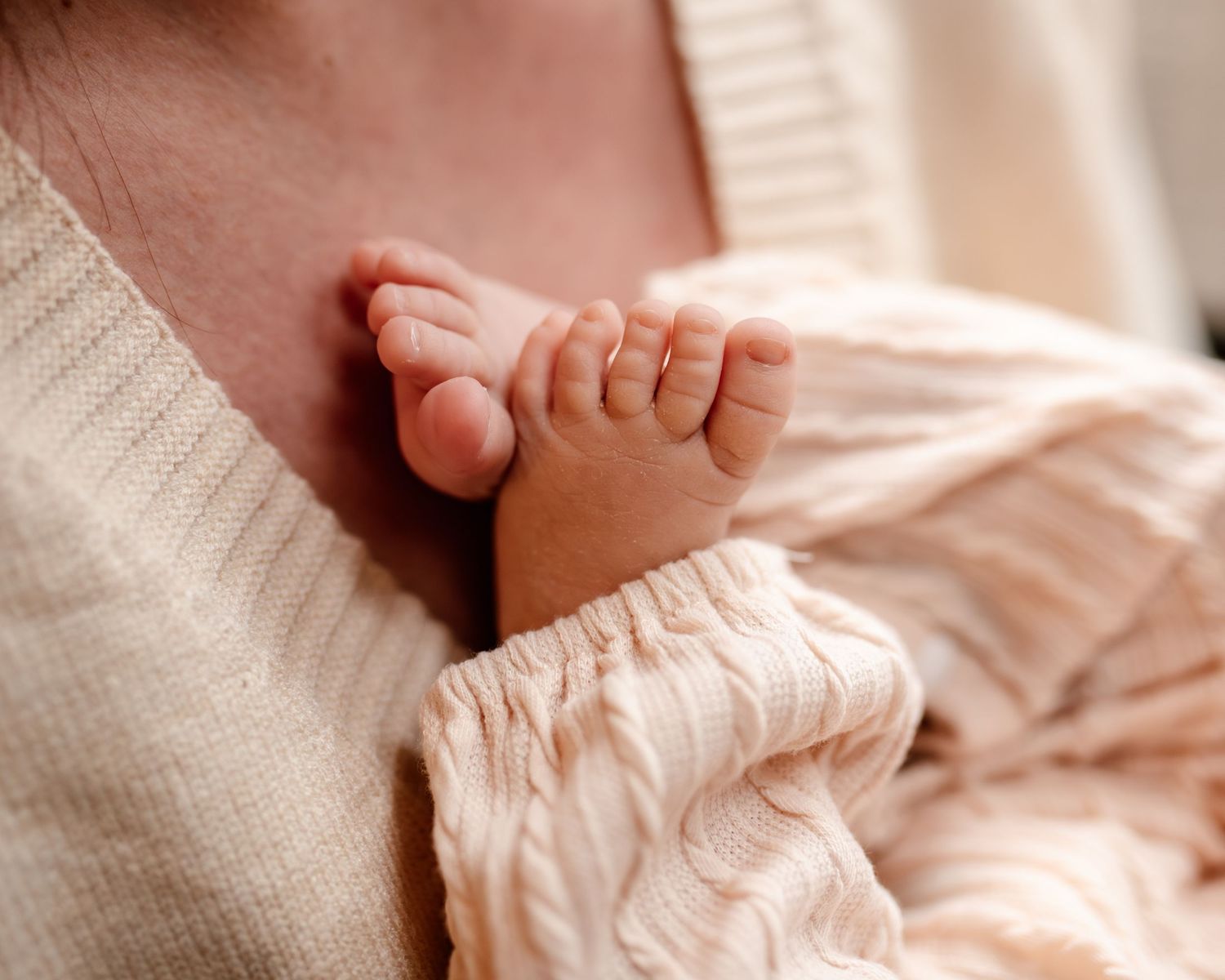 newborn feet resting on moms chest