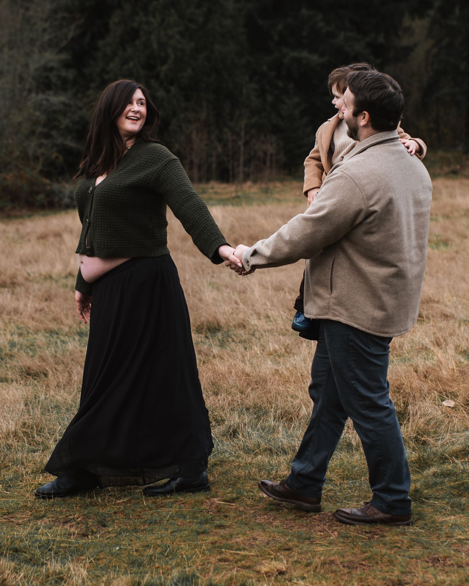 mom is leading dad and son on a walk during a maternity session