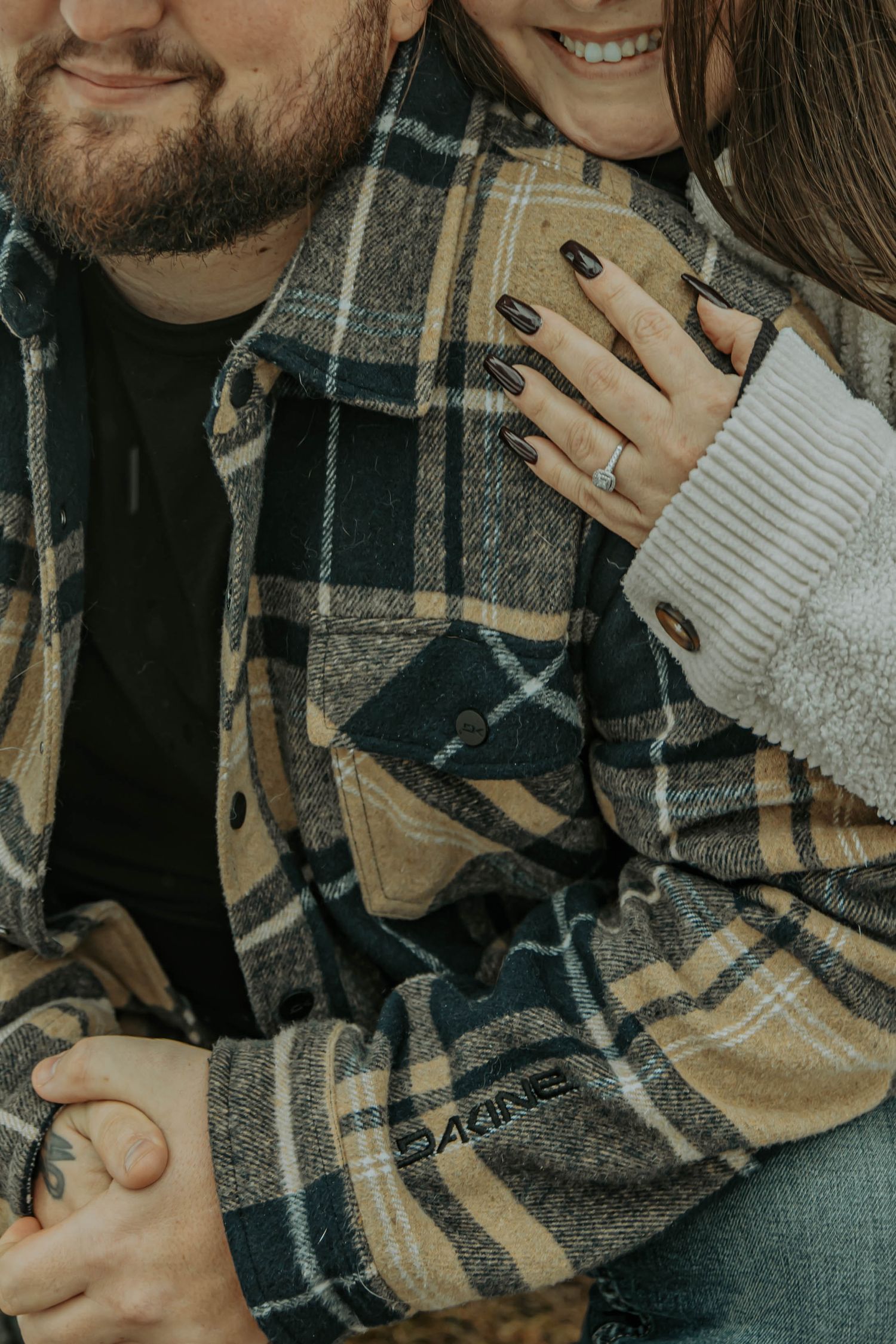 Couple in cozy winter attire sharing an intimate moment while wearing plaid and knit clothing.
