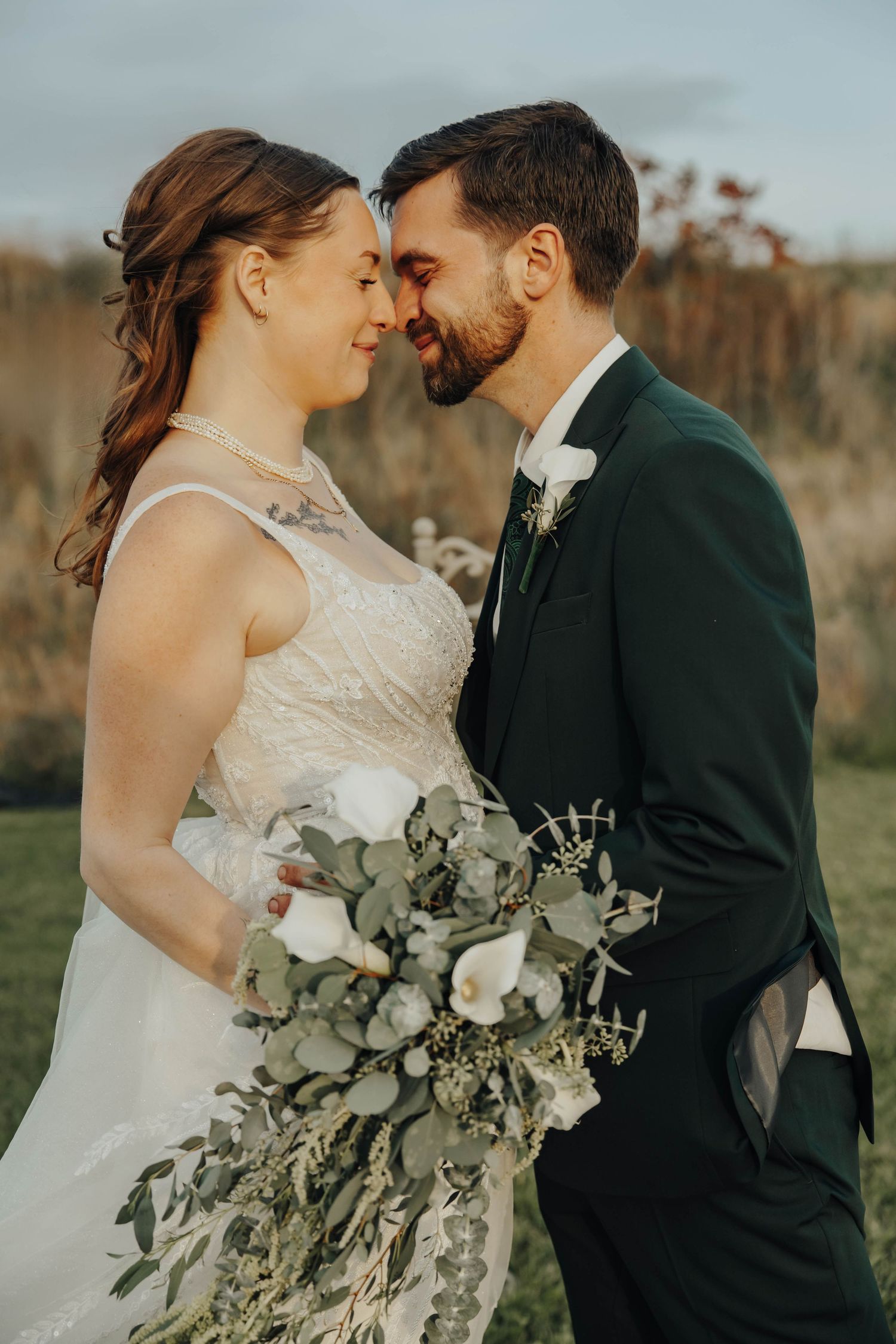Intimate wedding portraits show tender moments between newlyweds holding an elegant white and green bouquet.