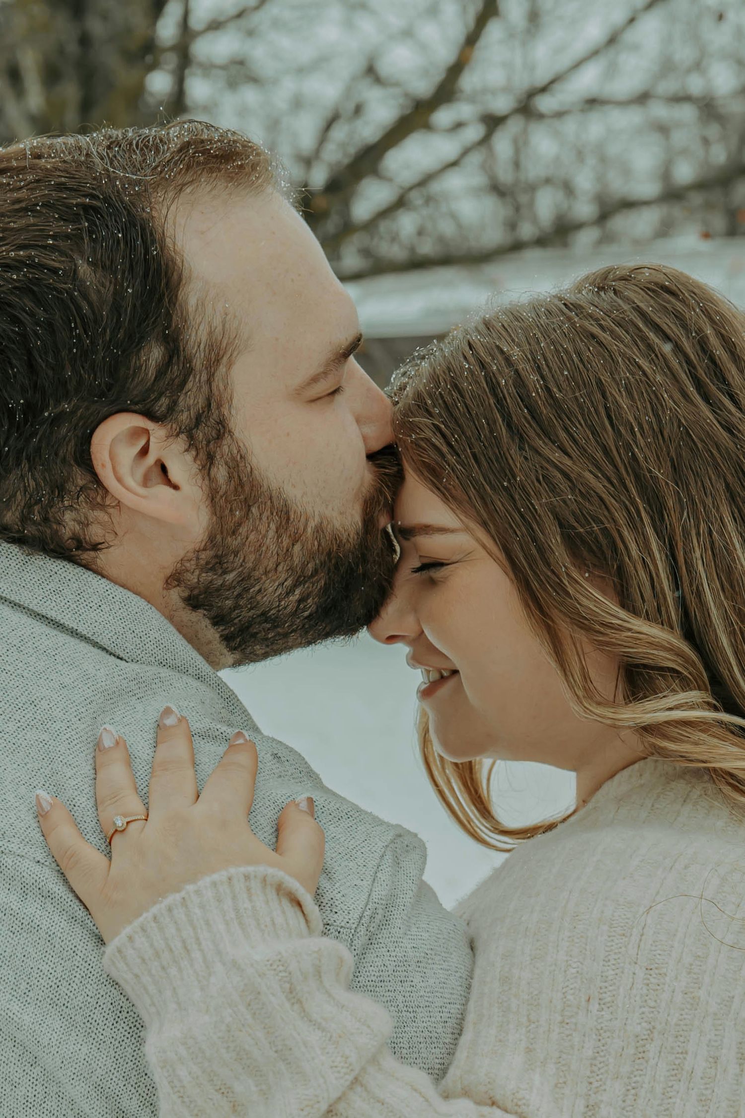 A romantic couple in cozy sweaters share intimate moments in a series of tender winter photographs.