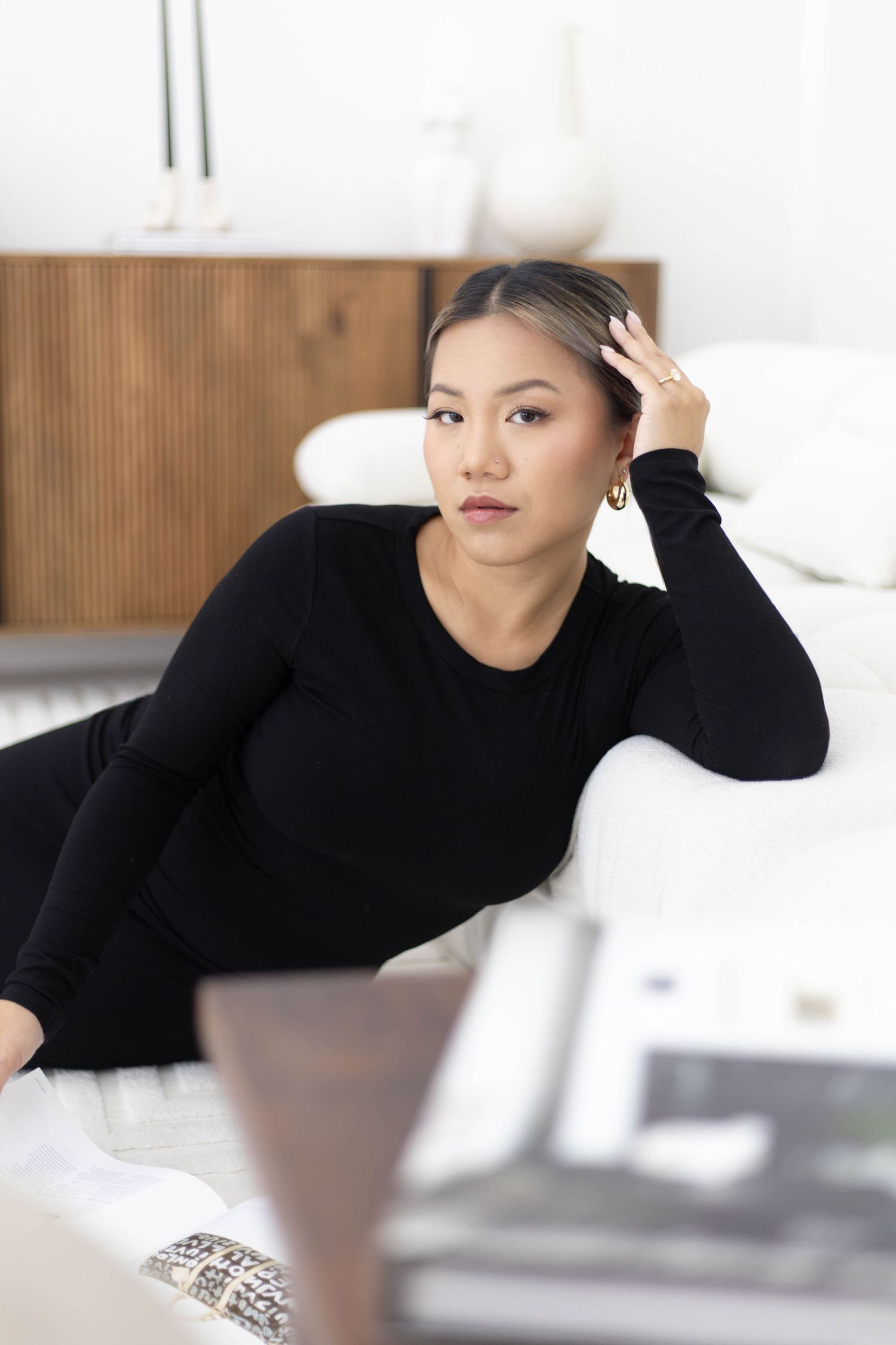 Modern dancer in black turtleneck performs expressive poses against minimalist white setting.