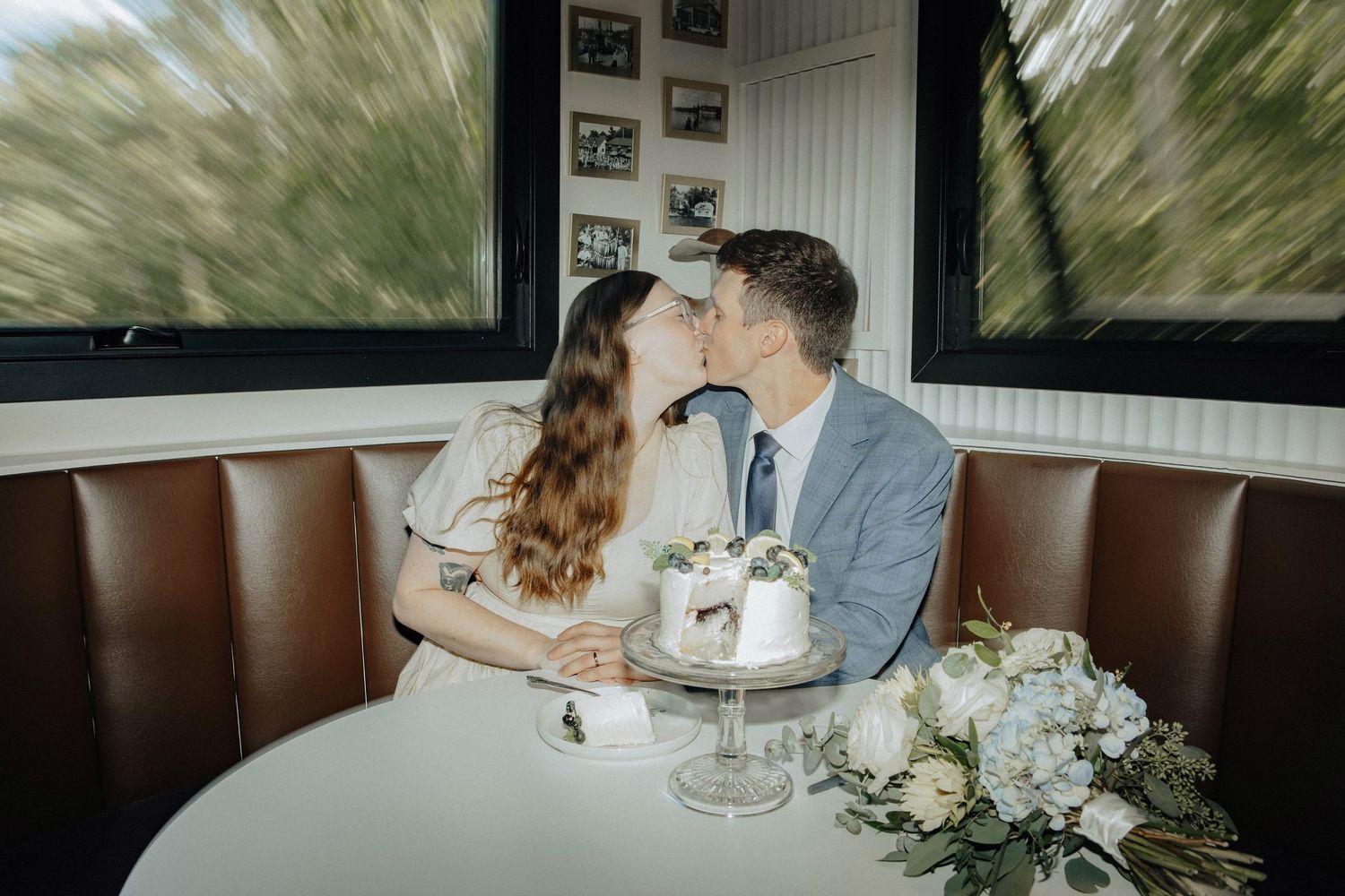 A couple cutting their wedding cake together with a silver cake knife.
