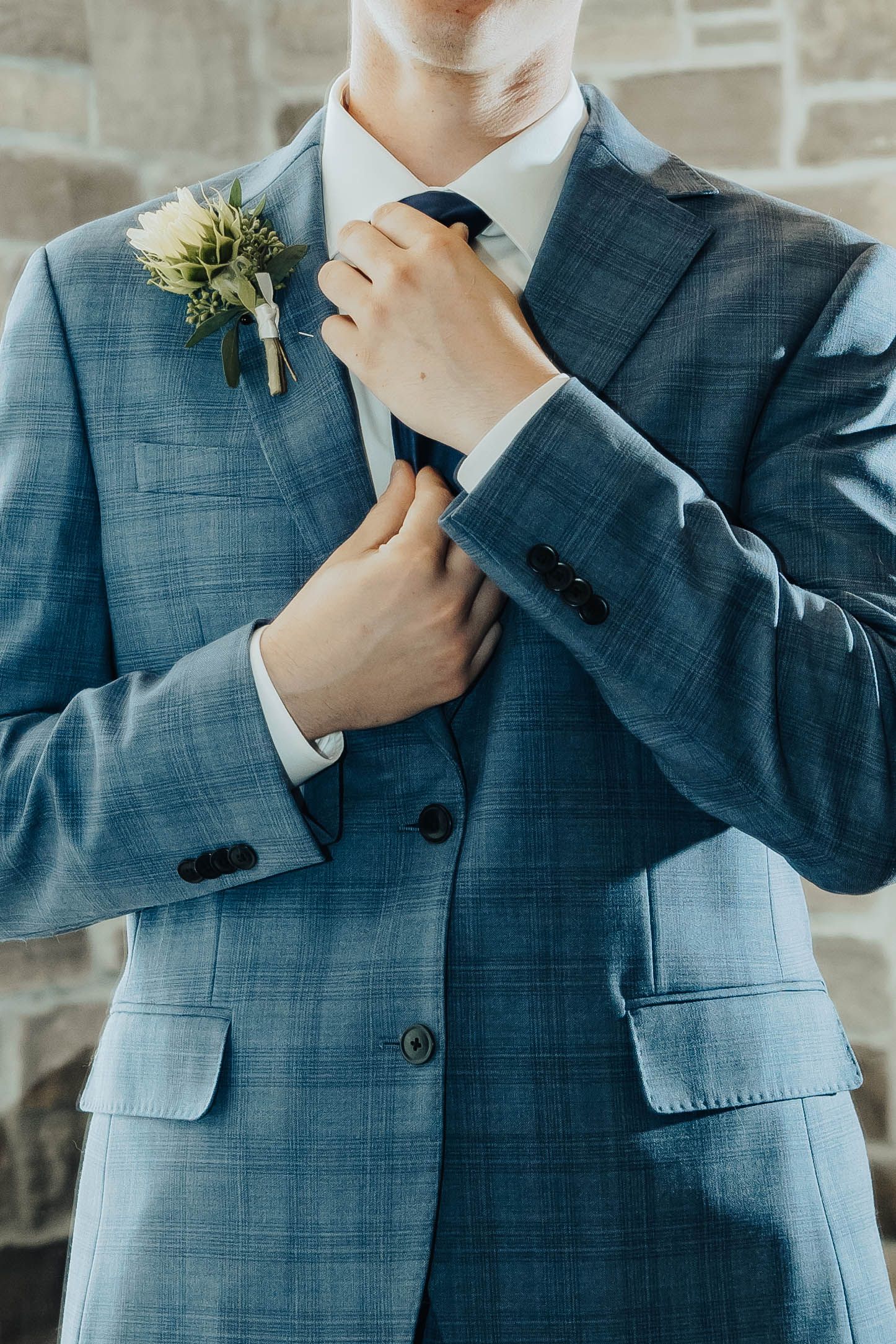 Close-up shots show a groom in a blue plaid suit adjusting his boutonniere.