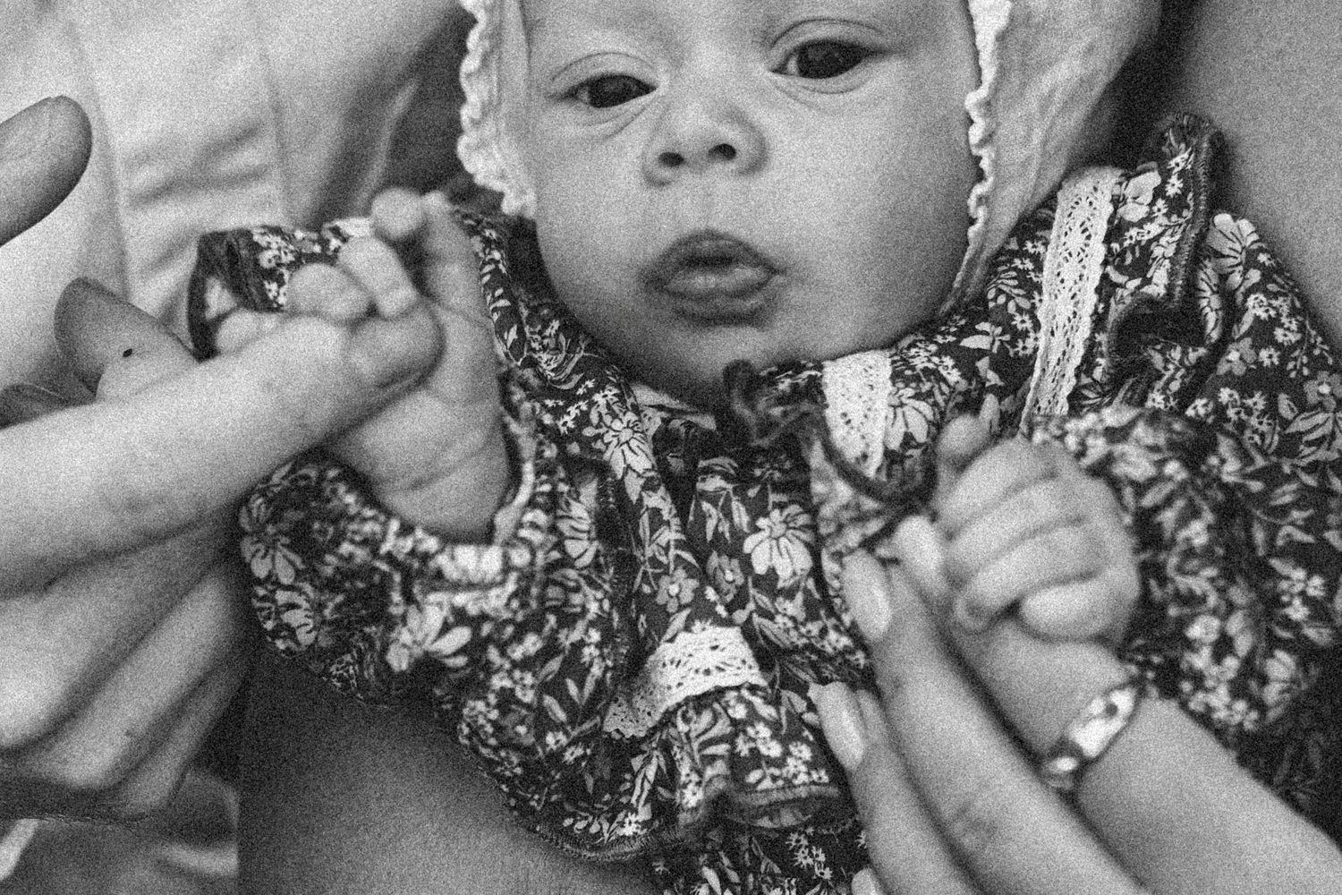 Black and white mosaic of newborn baby portraits showing different expressions and angles.