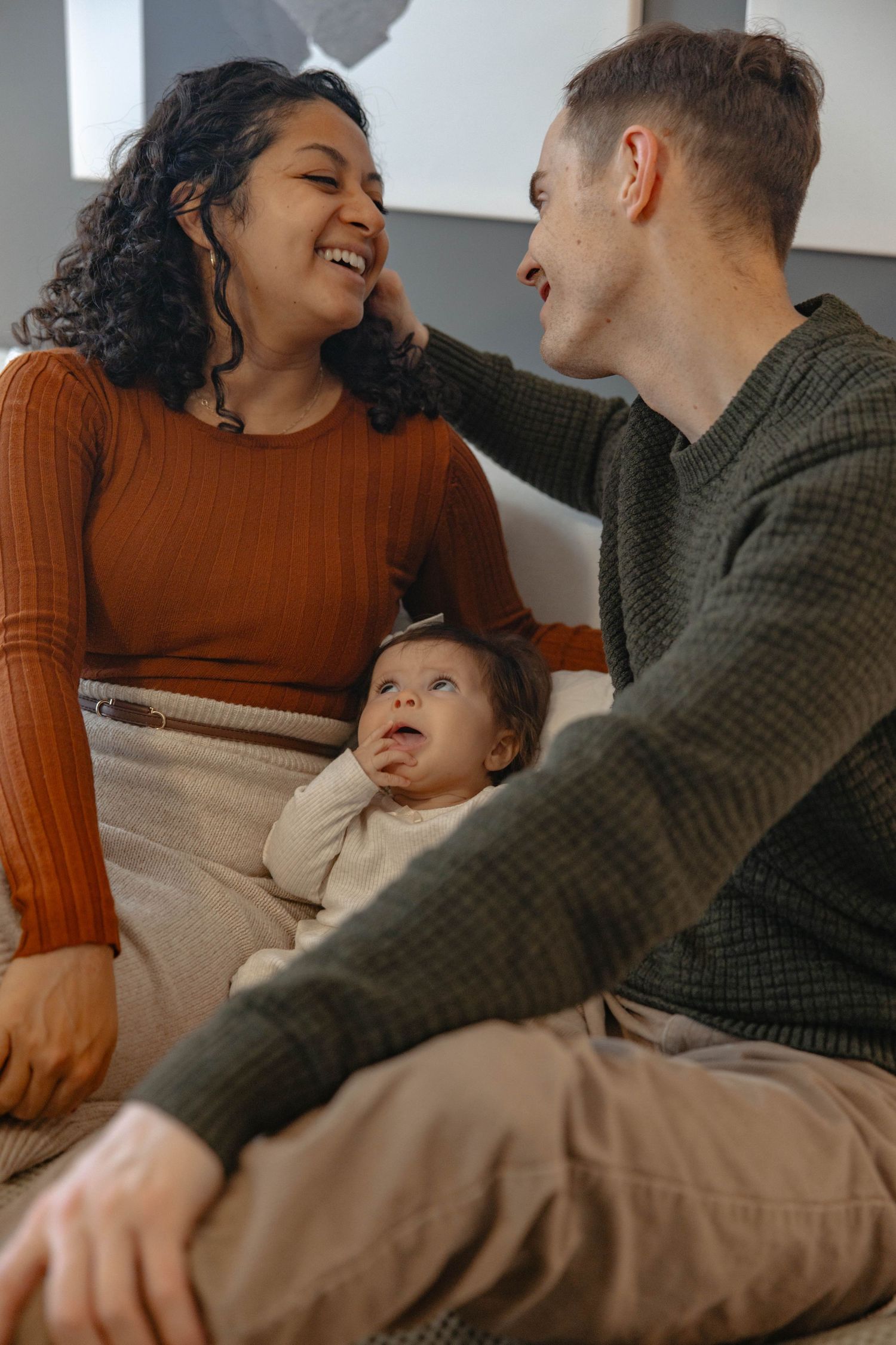 An intimate family moment filled with laughter and joy as they relax together on comfortable furniture.