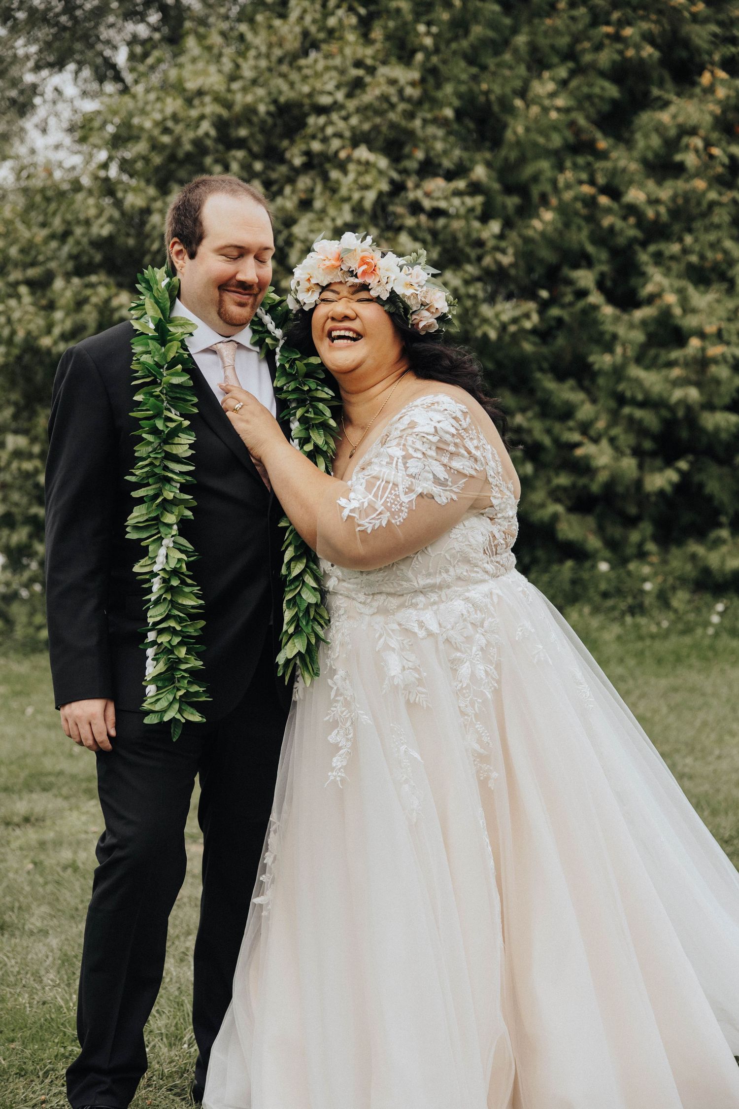 A couple shares a joyful first look moment during their outdoor garden wedding.
