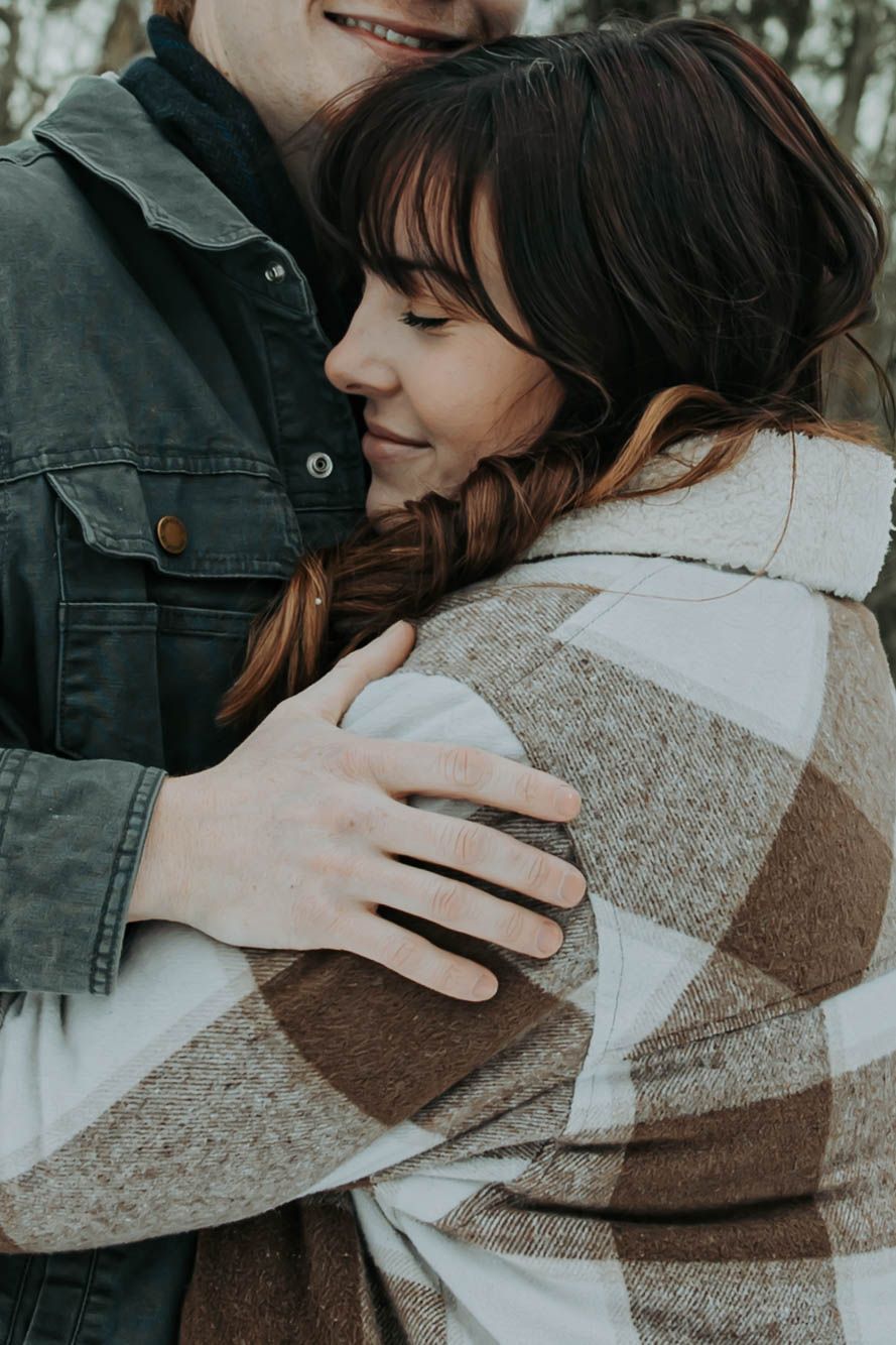 Close-up series showing a tender embrace between two people wearing denim and a cozy plaid sweater.