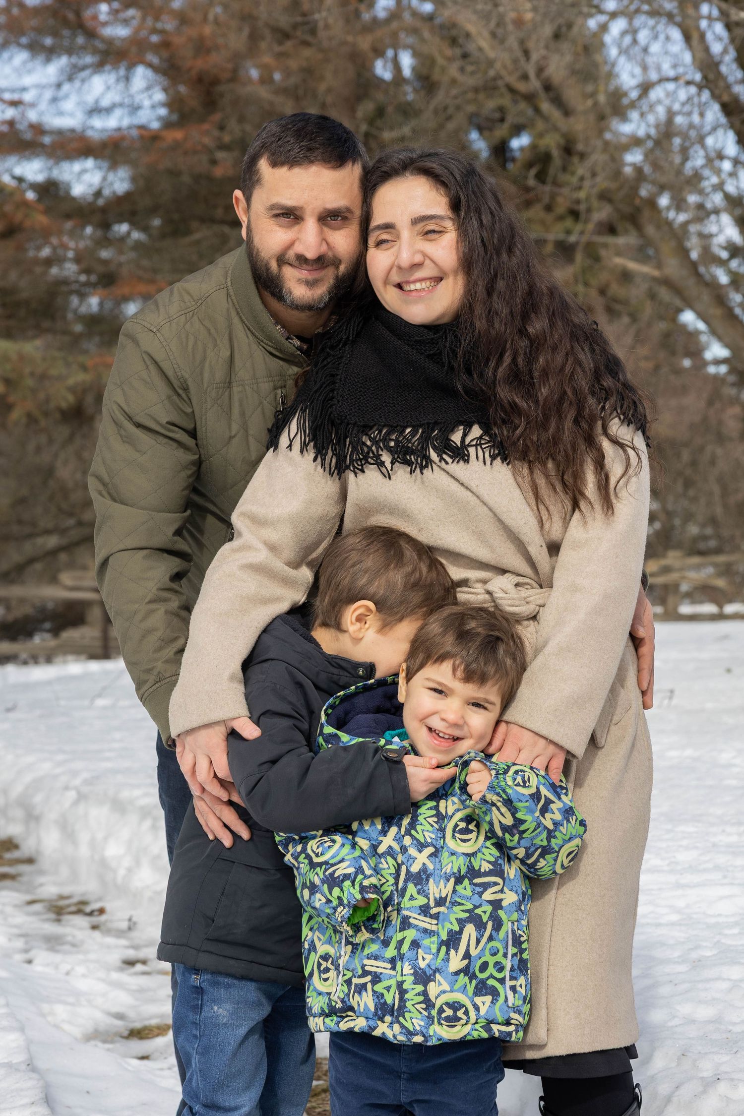 A family shares joyful moments together in the snow, wearing winter coats and embracing in a series of candid photos.