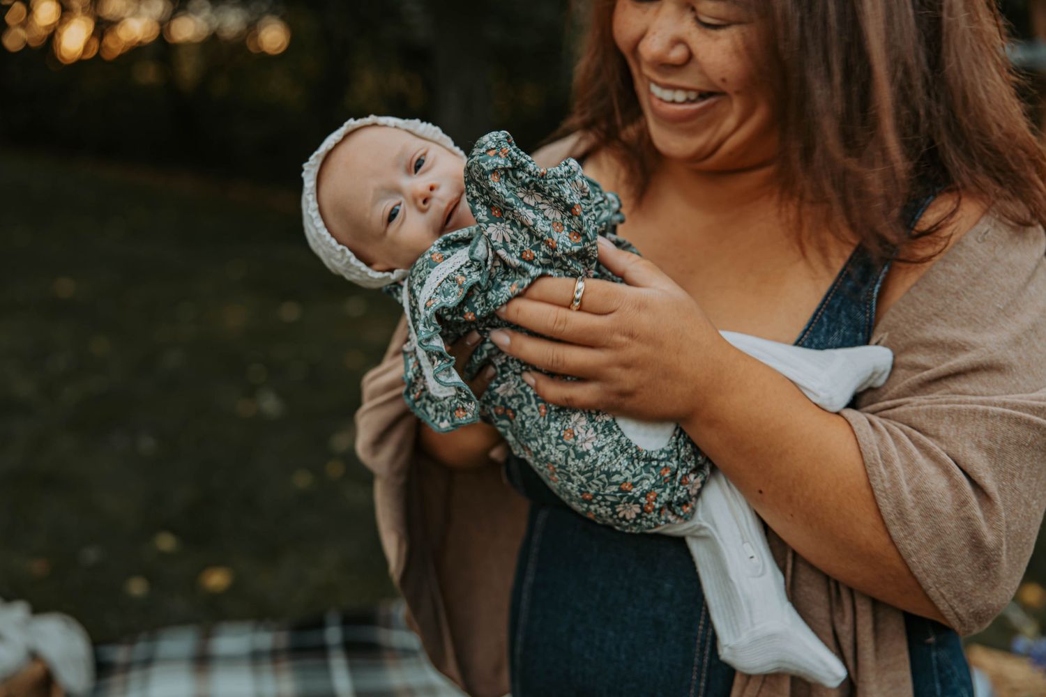 A tender family photo session outdoors during golden hour showing loving interactions between parents and baby.