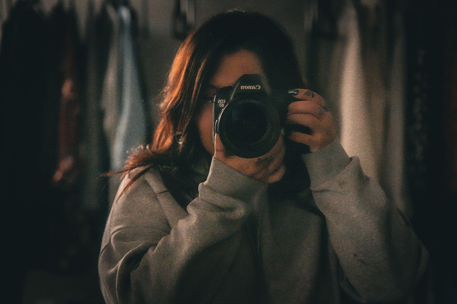 Someone taking a coffee product photo holding up a cup, creating a lifestyle shot in a cozy interior setting.