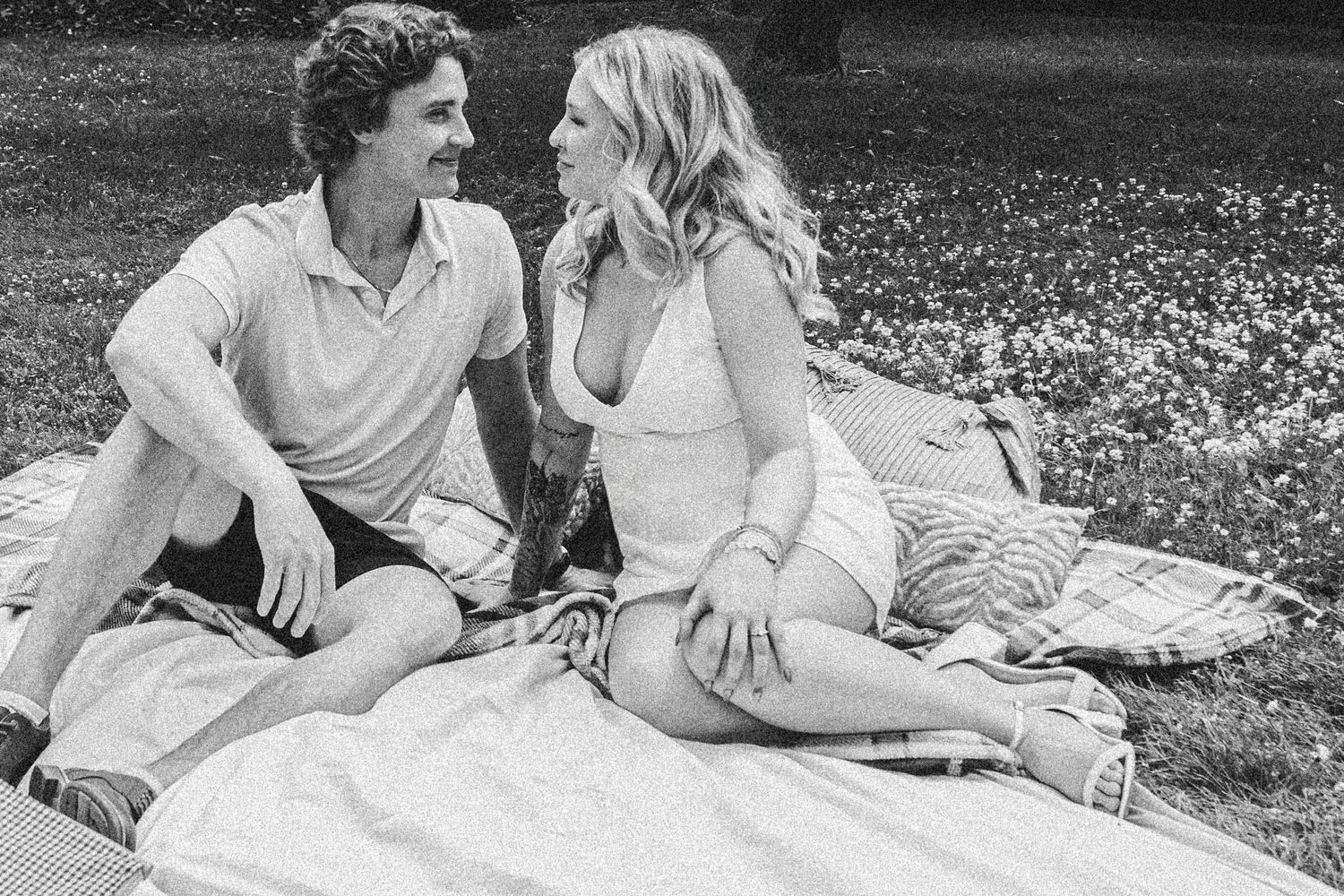 A series of romantic black and white images showing a couple enjoying a picnic outdoors together.