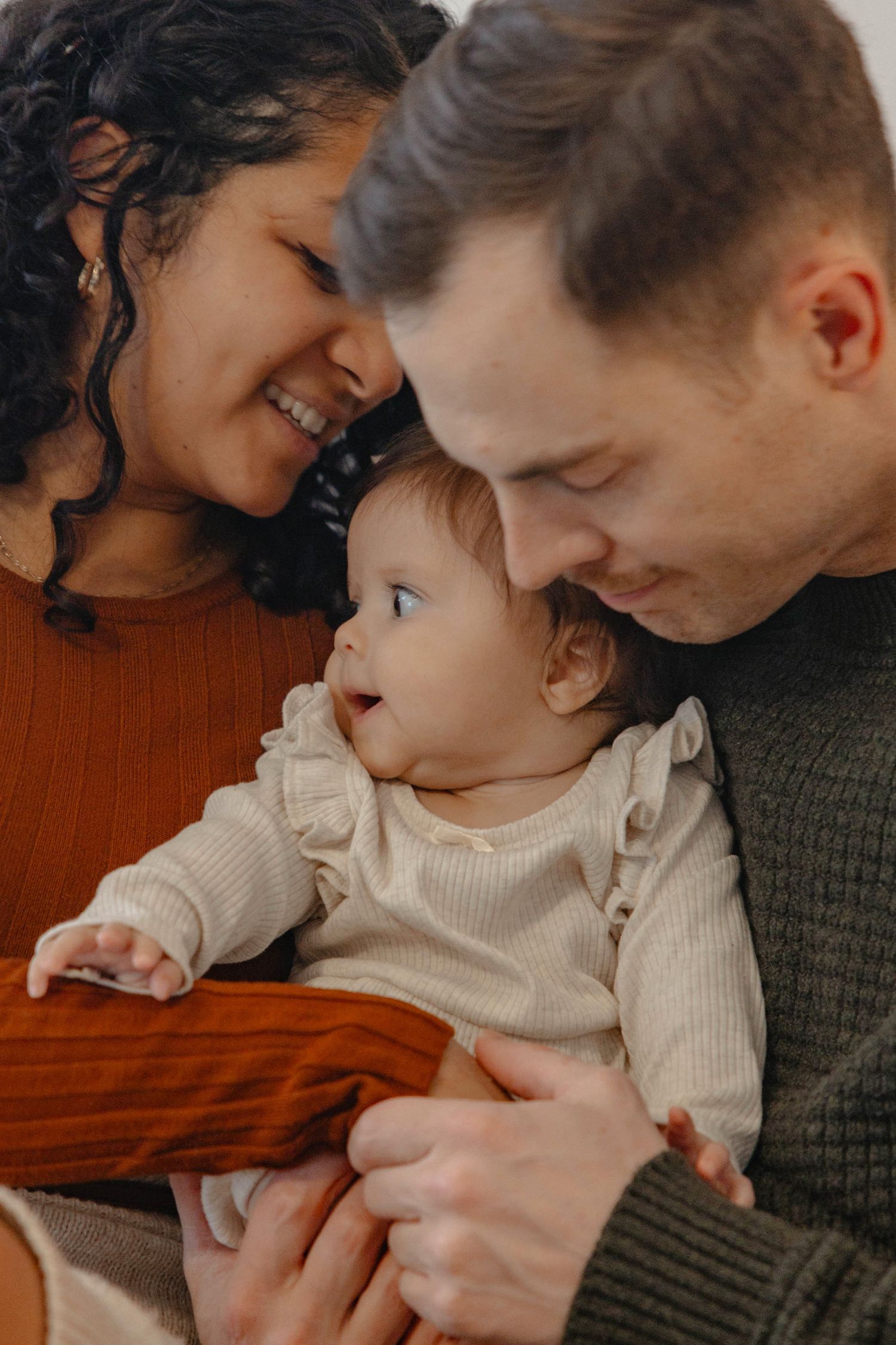 A tender family moment shared between parent and child on a wooden surface in warm lighting.