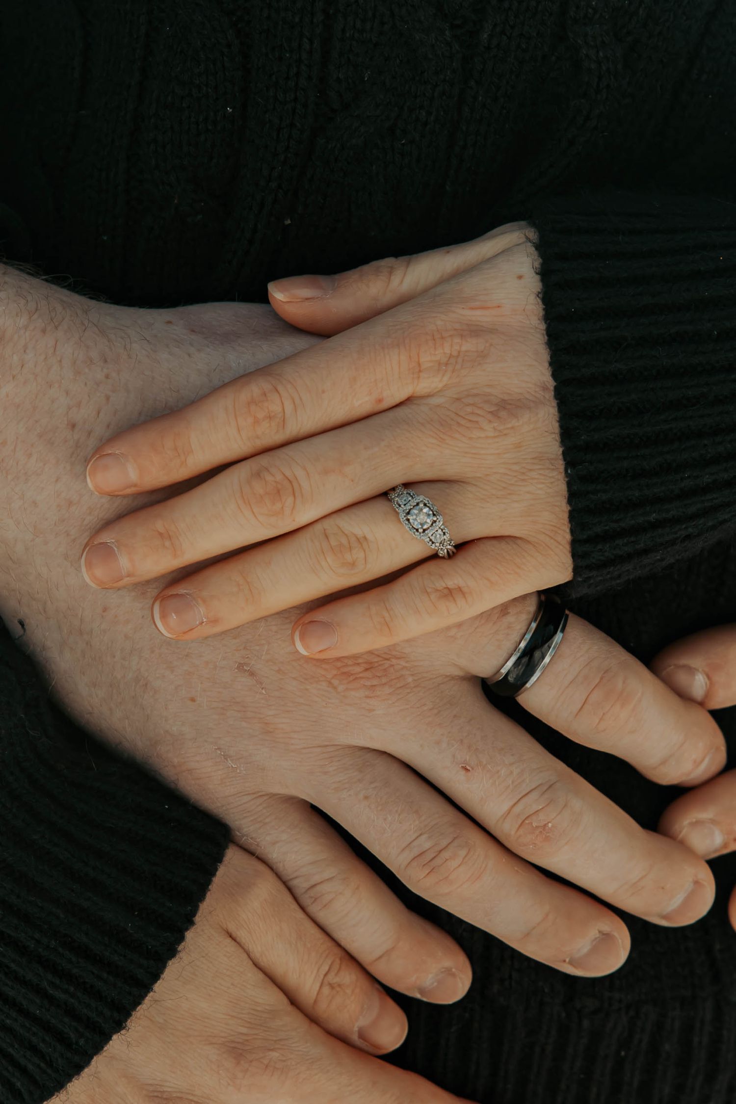 Close-up sequence showing hands exchanging wedding rings during a ceremony against a dark background.
