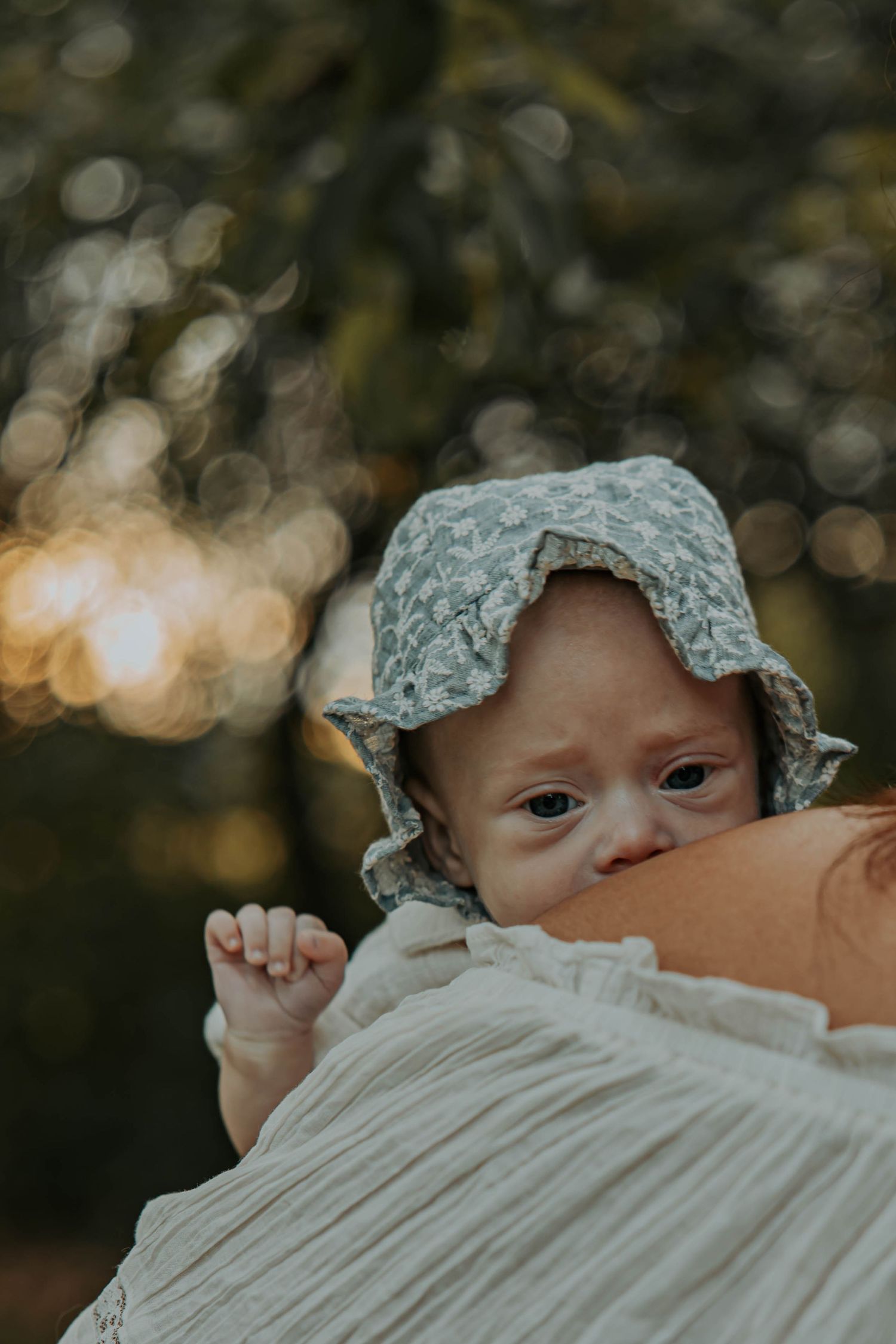 Close up sequence of an infant wearing a lace bonnet looking up with curious expressions.