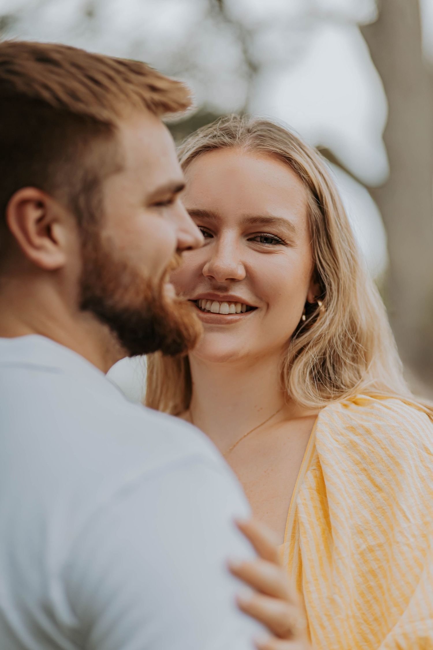 A romantic golden hour portrait shows a couple in love sharing an intimate moment outdoors.