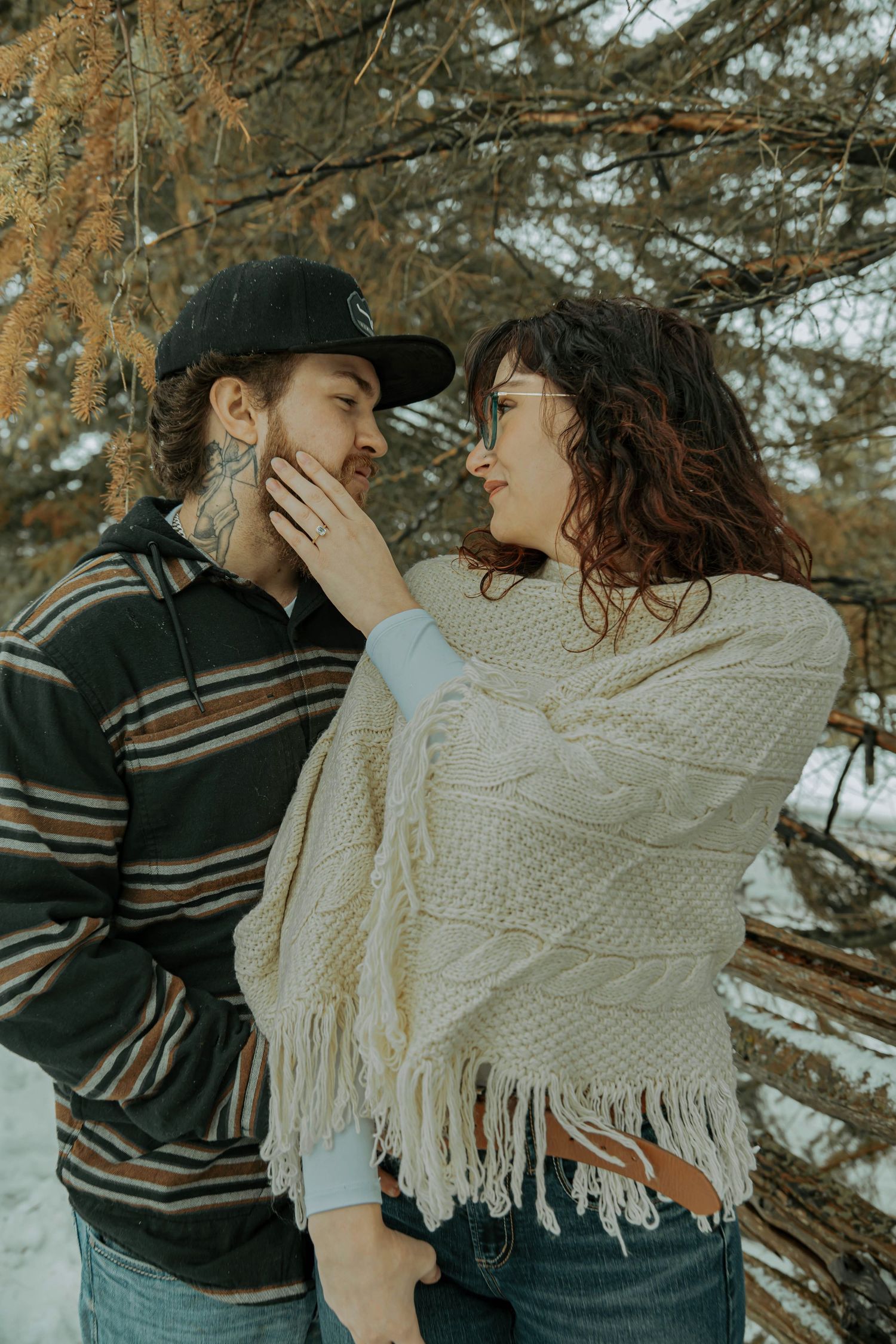 A romantic autumn portrait of a couple in casual wear sharing an intimate moment outdoors in nature.