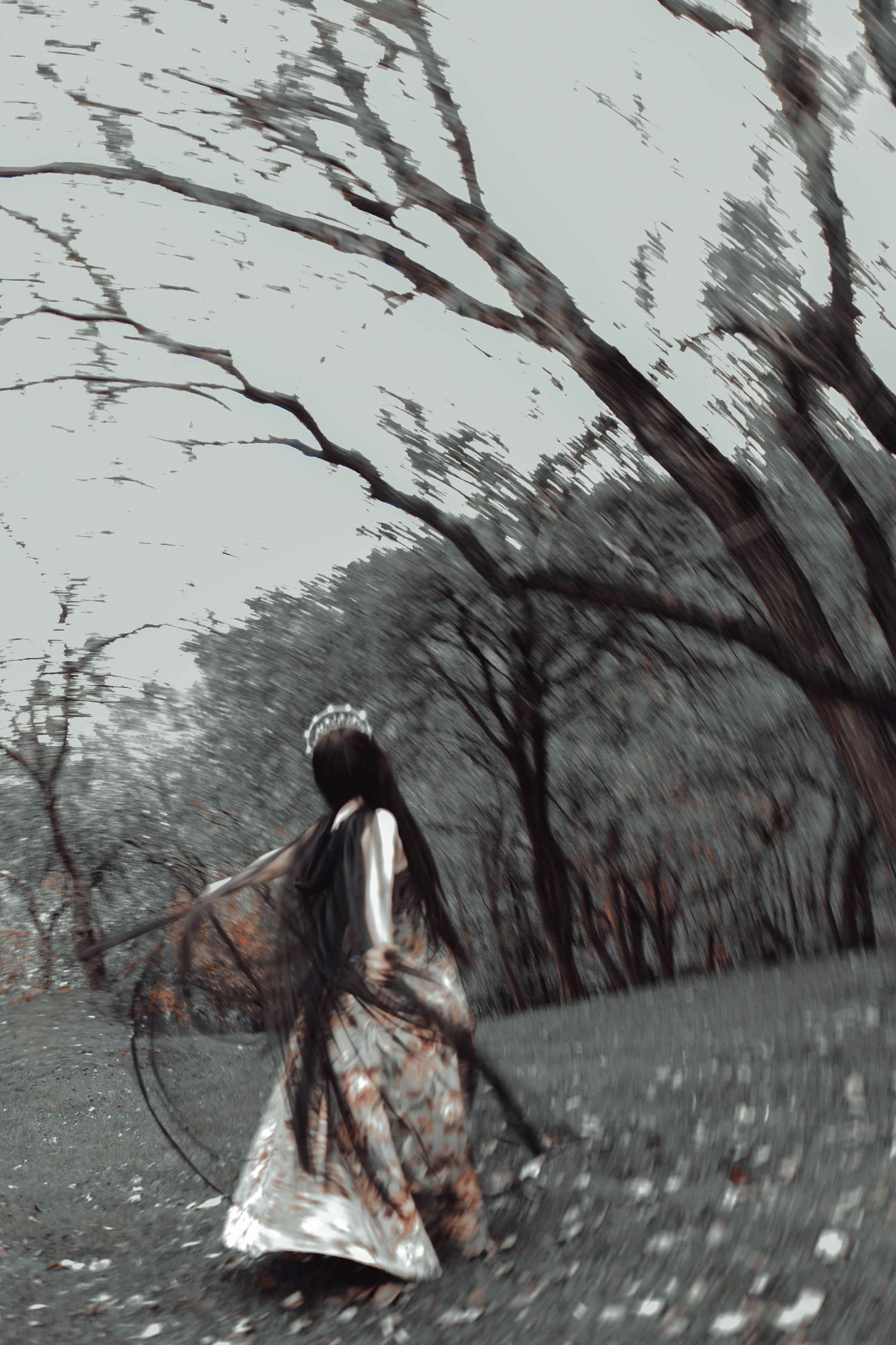 A series of black and white photographs showing a person in a white dress moving through a misty wooded area.