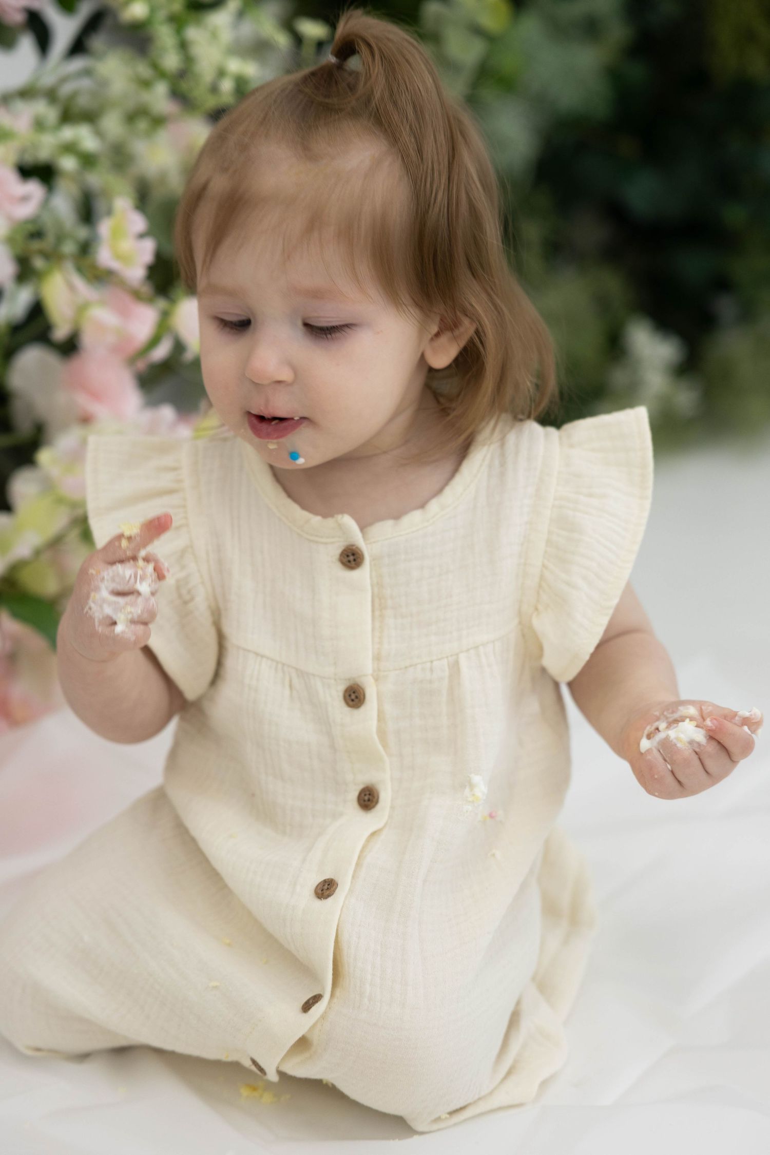 A delightful scene with soft cream fabric and delicate pink flowers creating an ethereal spring atmosphere.