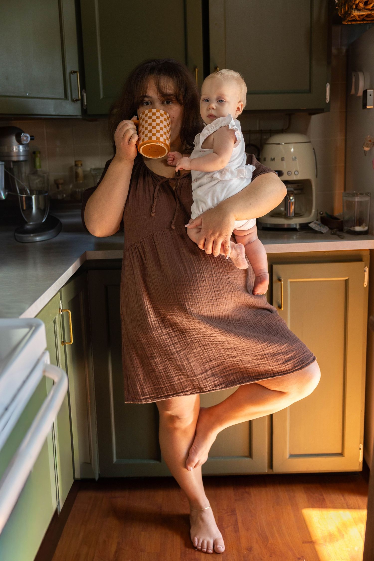 A series of images showing a toddler in a brown dress standing in a sunlit kitchen.