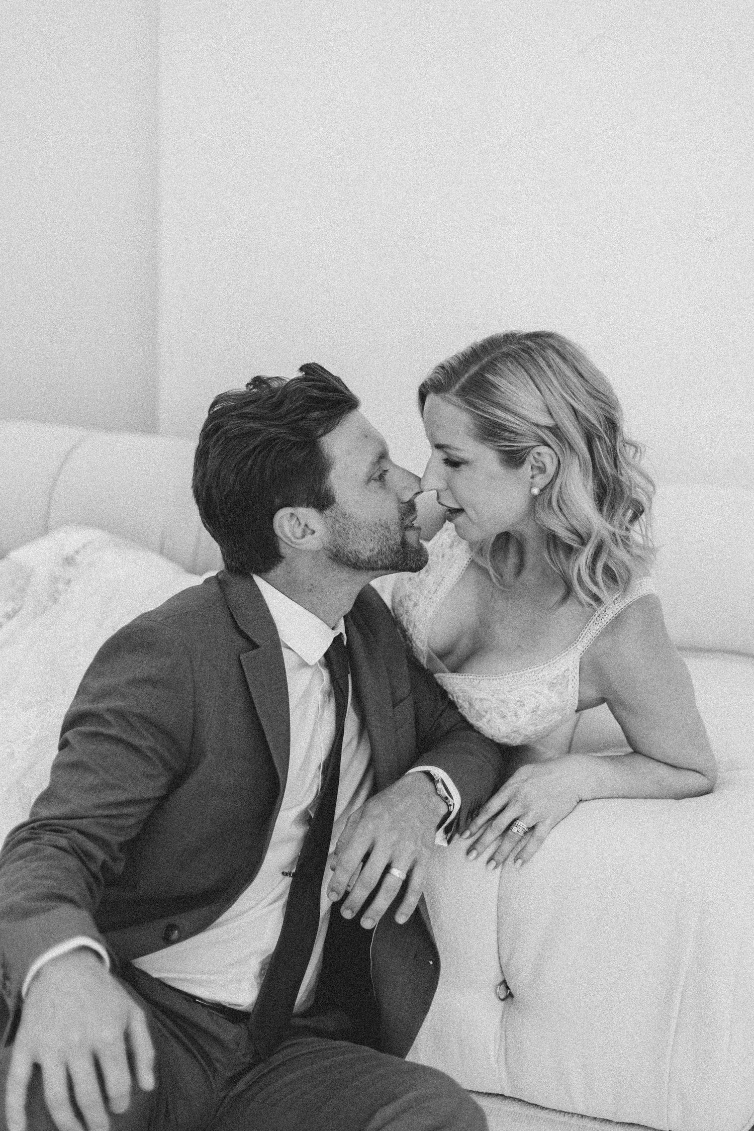 A romantic black and white photo sequence showing a couple sharing tender moments together on a white couch.