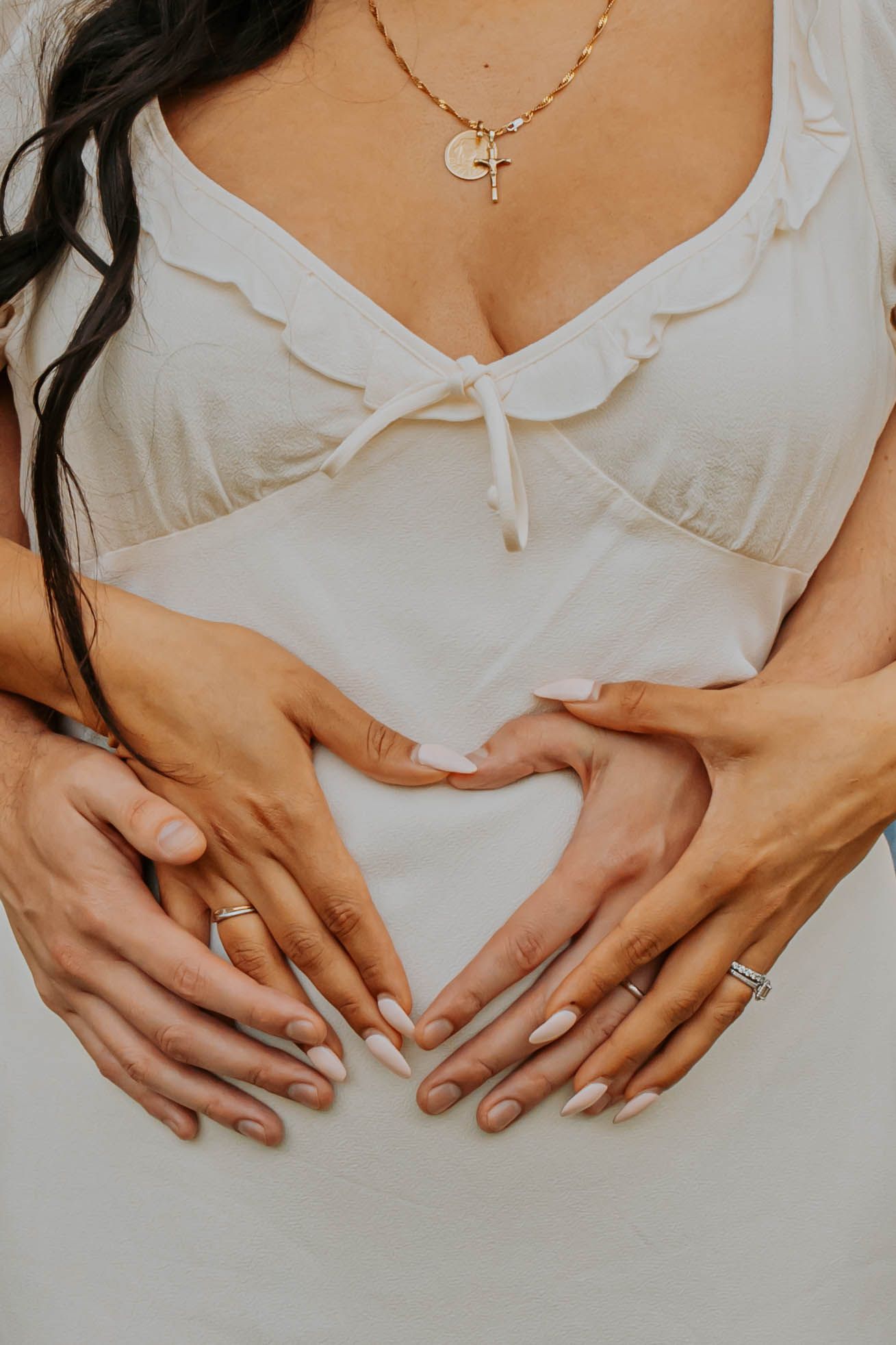 Sequence of hands resting on a white fabric surface forming a visual progression with delicate finger placements.