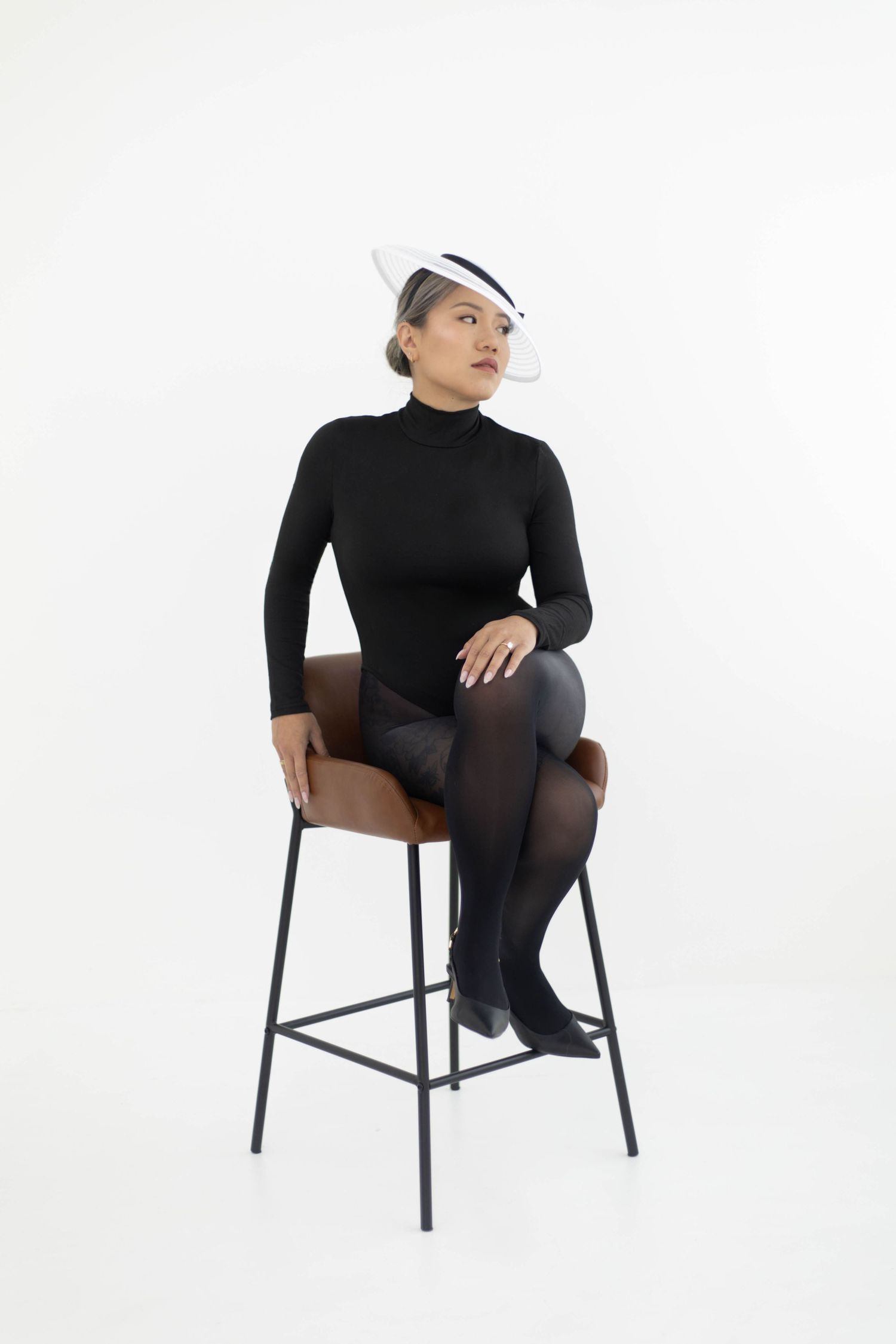 Minimalist portrait series in black attire showing different seated poses against a white backdrop.